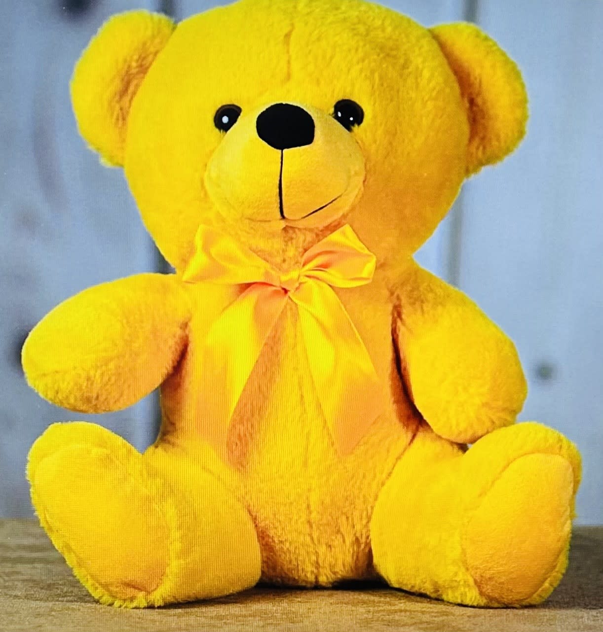 Yellow teddy bear with a satin bow