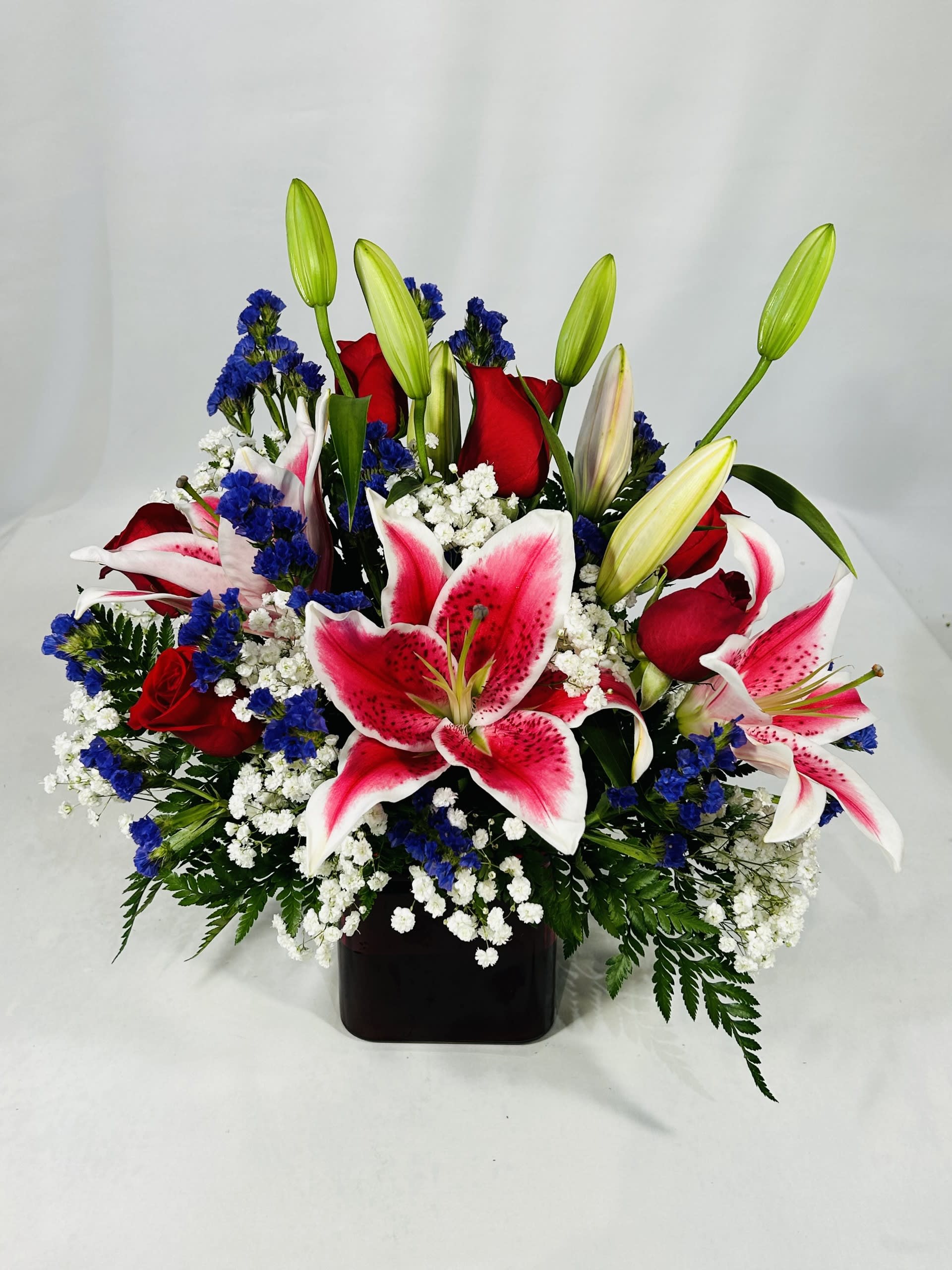Bouquet of red roses and pink lilies in a black vase