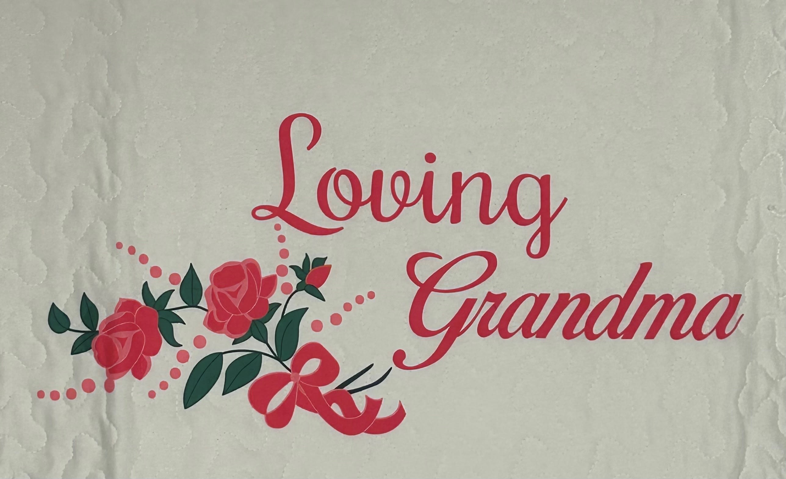 Quilted fabric with pink "Loving Grandma" text and rose graphics