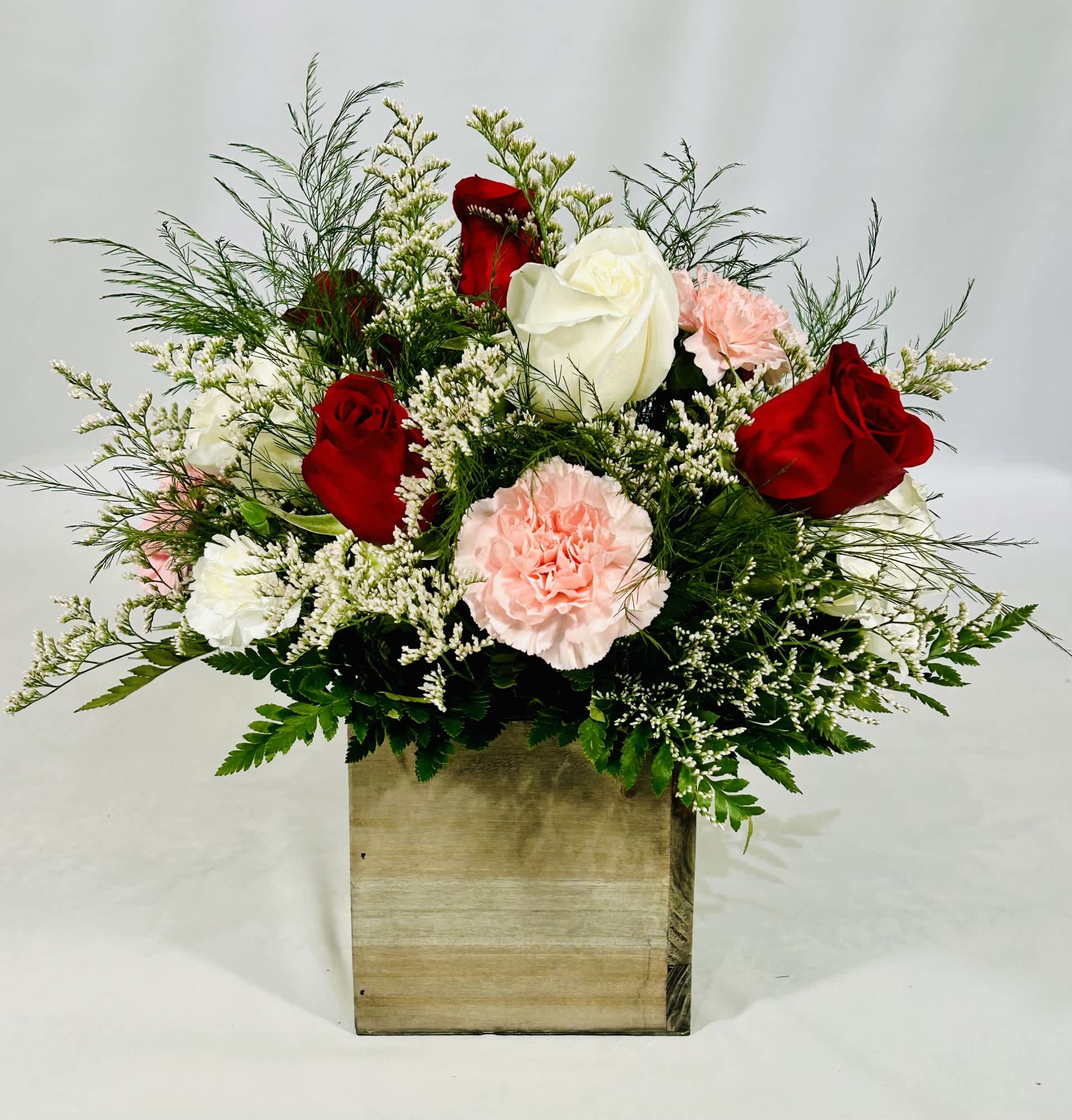 Red and white roses with pink carnations in a wooden box