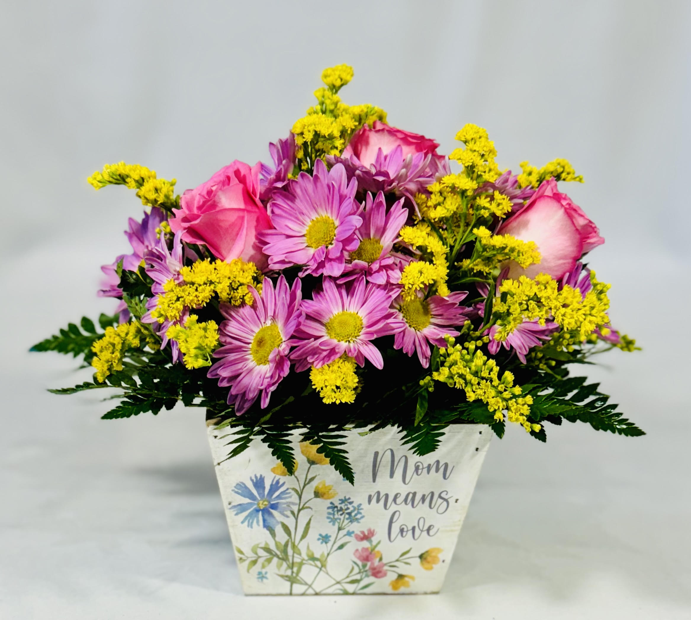Pink roses and purple daisies in a decorative Mom planter