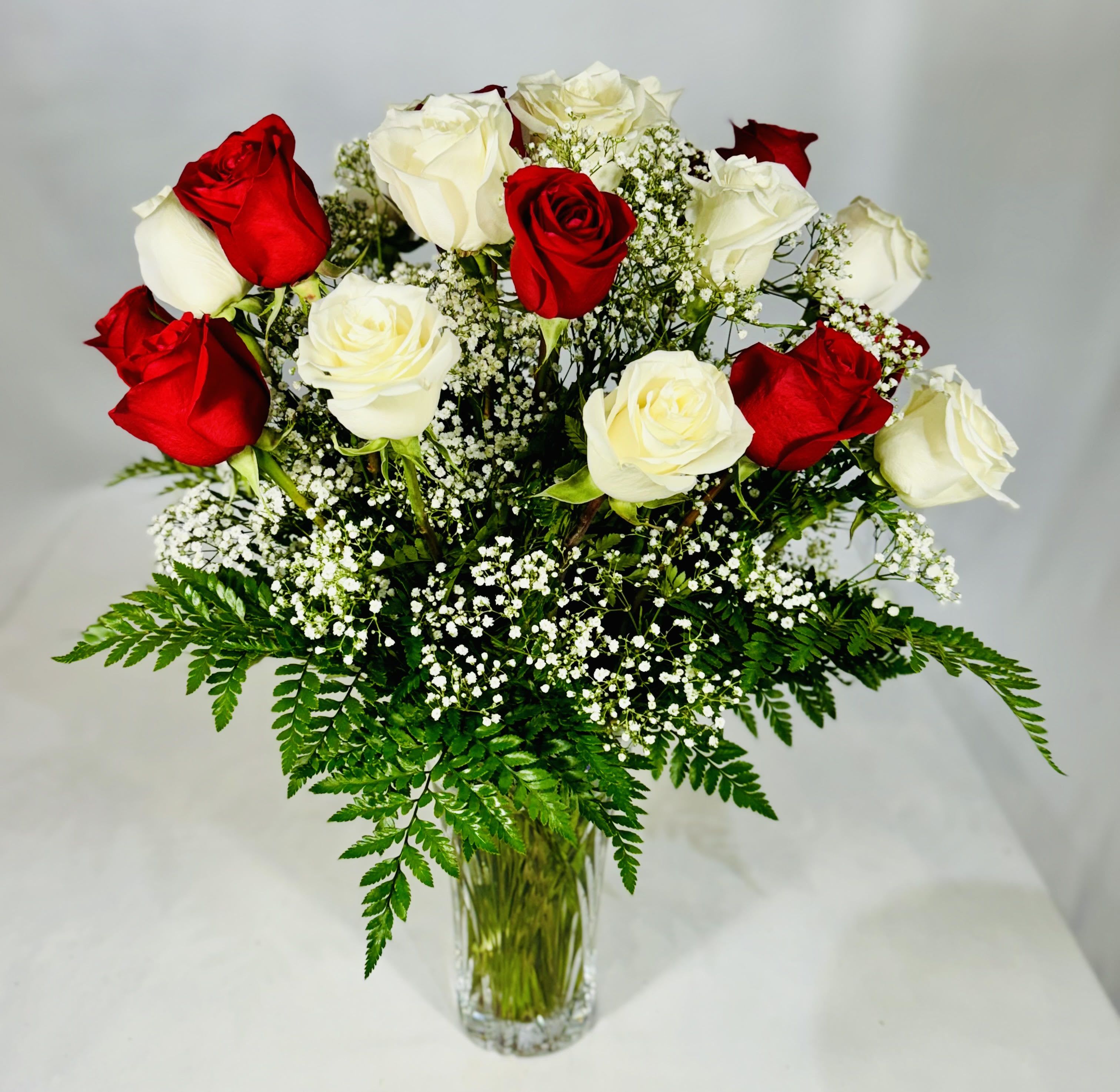 Red and white roses in a clear glass vase