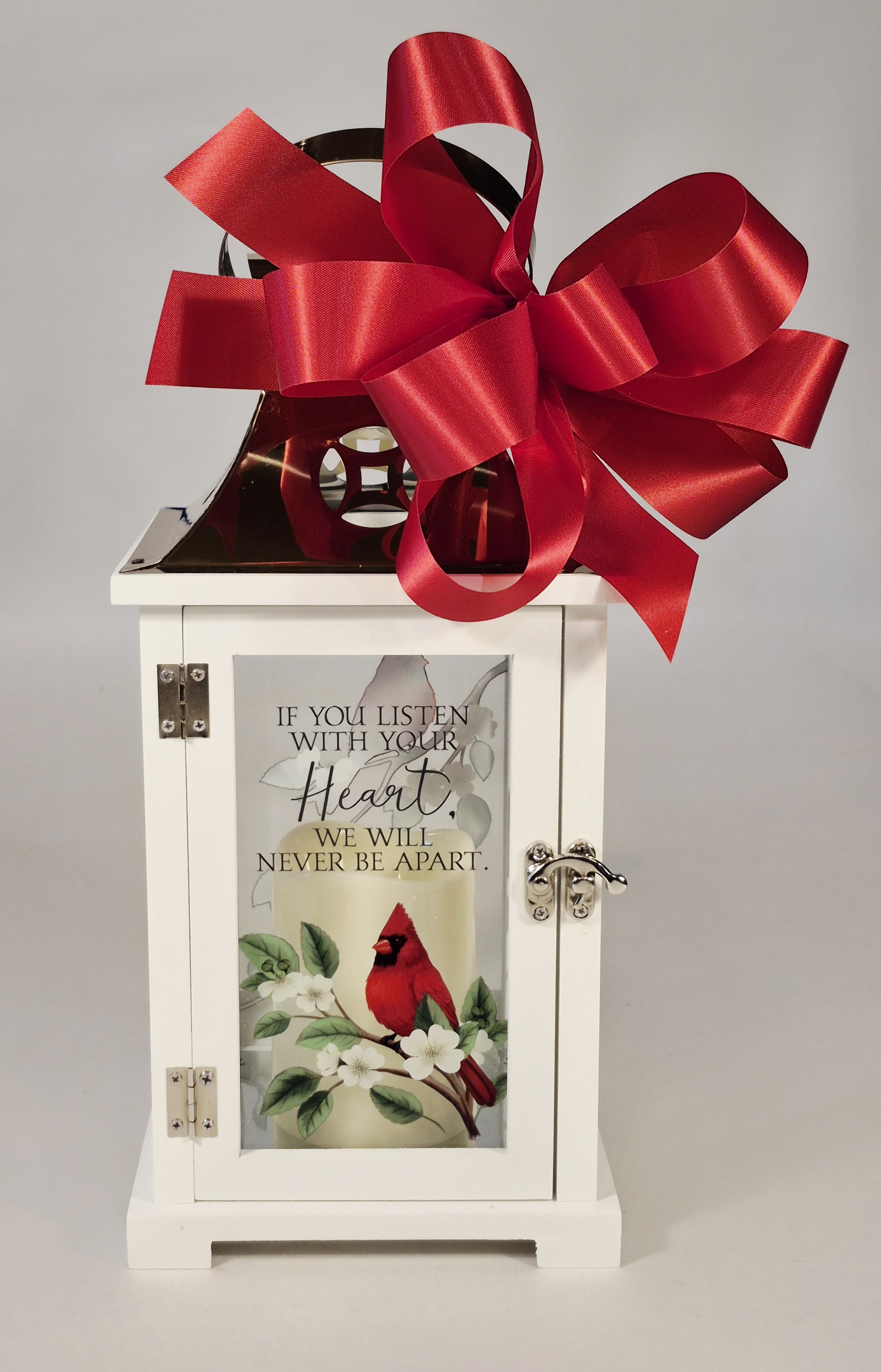 Listen With Your Heart Lighted Lantern - Lantern Saying: If you listen with your heart, we will never be apart. " Features red Cardinals and white flowering branches on all four sides. Our lanterns are made from quality composite wood and a stainless steel copper finish top. They feature a built-in automatic timer which runs for 6 hours on and 18 hours off(3-AAA batteries are included) and are inscribed with sentimental quotes. Suitable for hanging or free-standing use inside.  Reads: If You Listen With Your Heart We Will Never Be Apart Choose deluxe if you would like to add a Silk arrangement on lid of lantern.  W: 6.25" H: 13.5" D: 6.25"