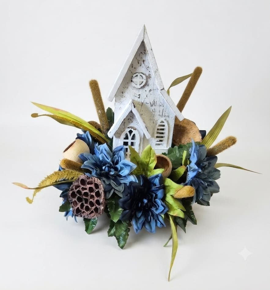 Blue floral arrangement with a white decorative church centerpiece