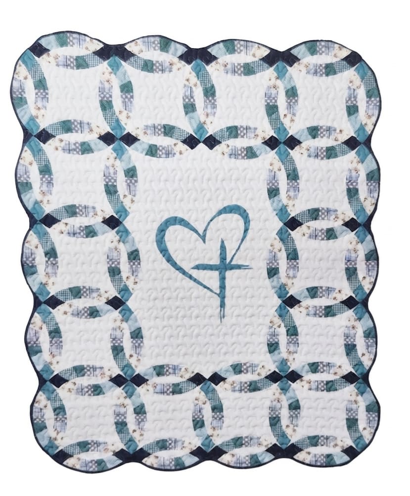 Quilted white blanket with blue ring pattern and a heart motif