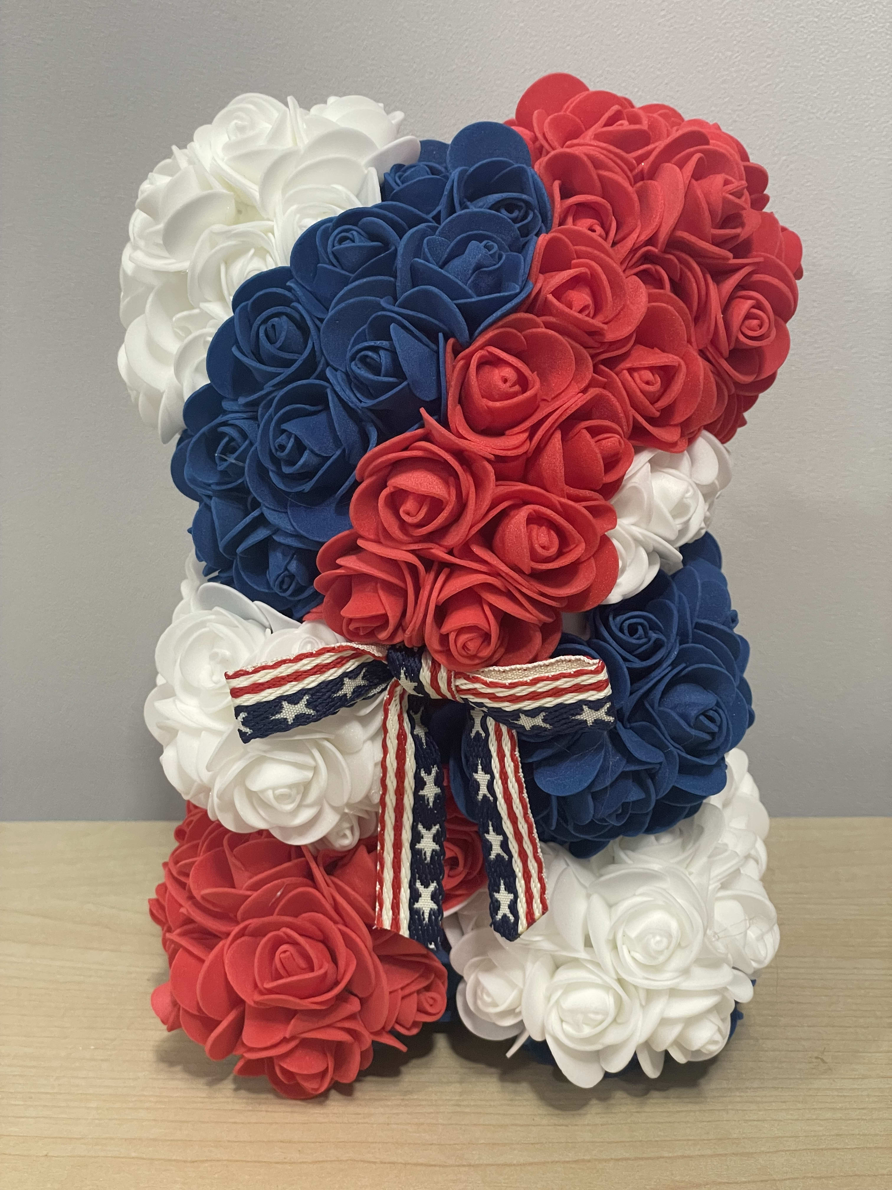 Red, white, and blue rose teddy bear with a patriotic ribbon