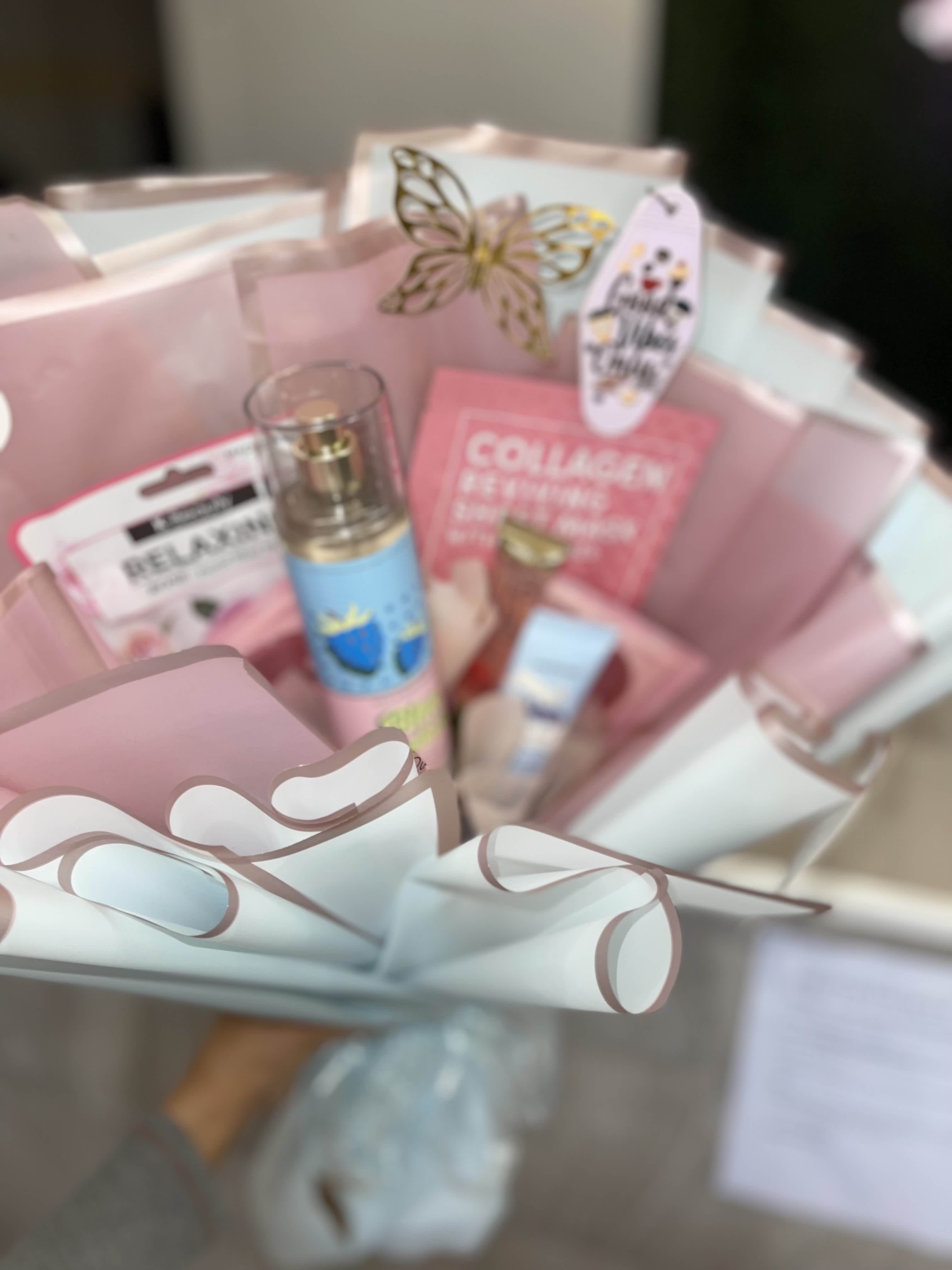 Pink gift basket with skincare items and a butterfly decoration