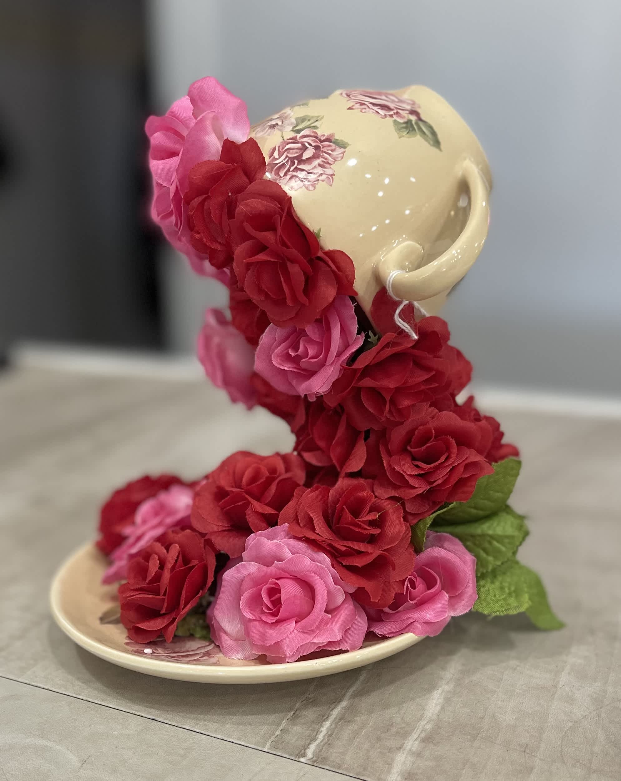 Ceramic teacup and saucer covered with pink and red roses