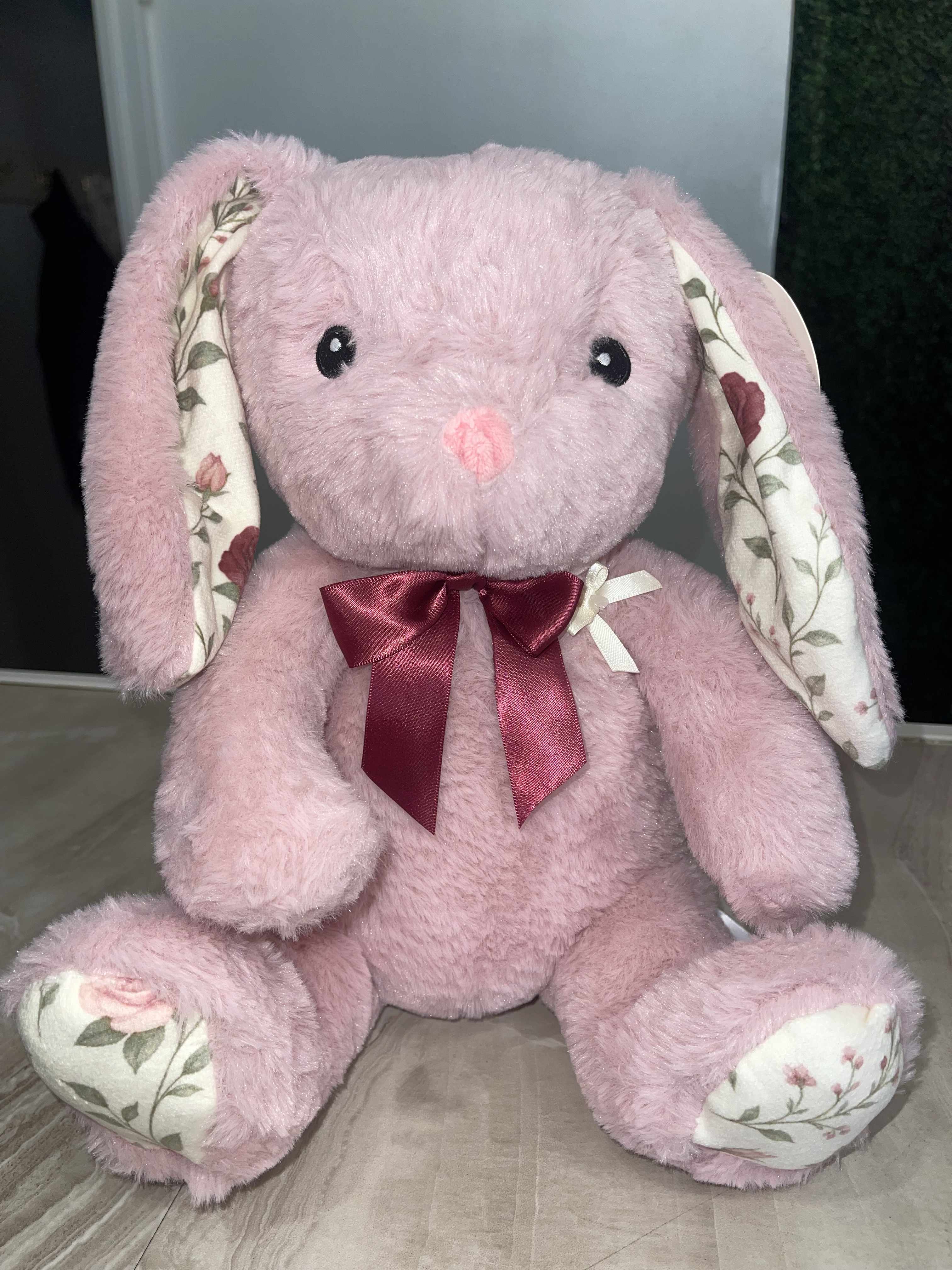 Pink plush bunny with floral-patterned ears and feet, wearing a burgundy bow
