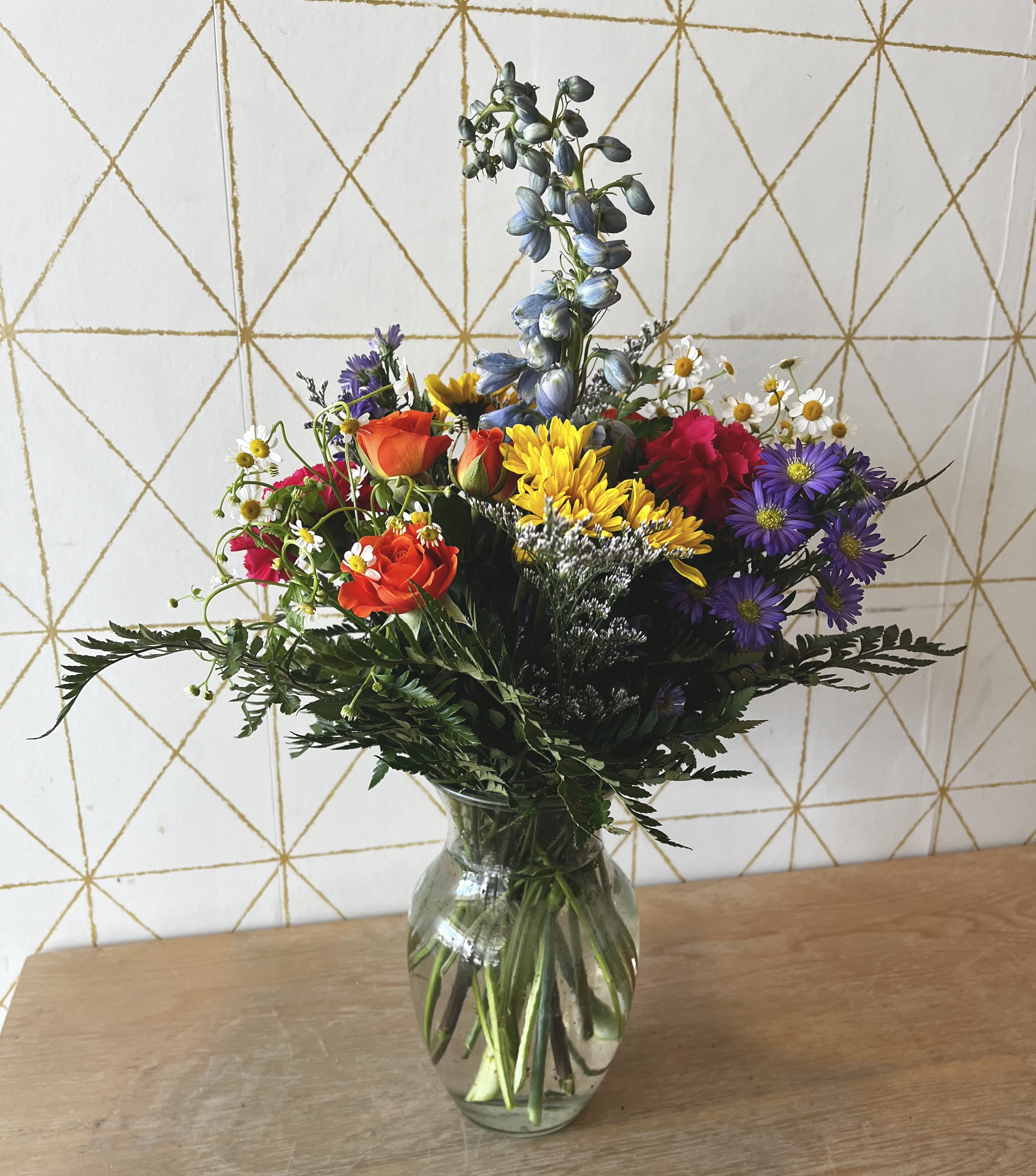 Mixed bouquet of colorful flowers in a clear glass vase
