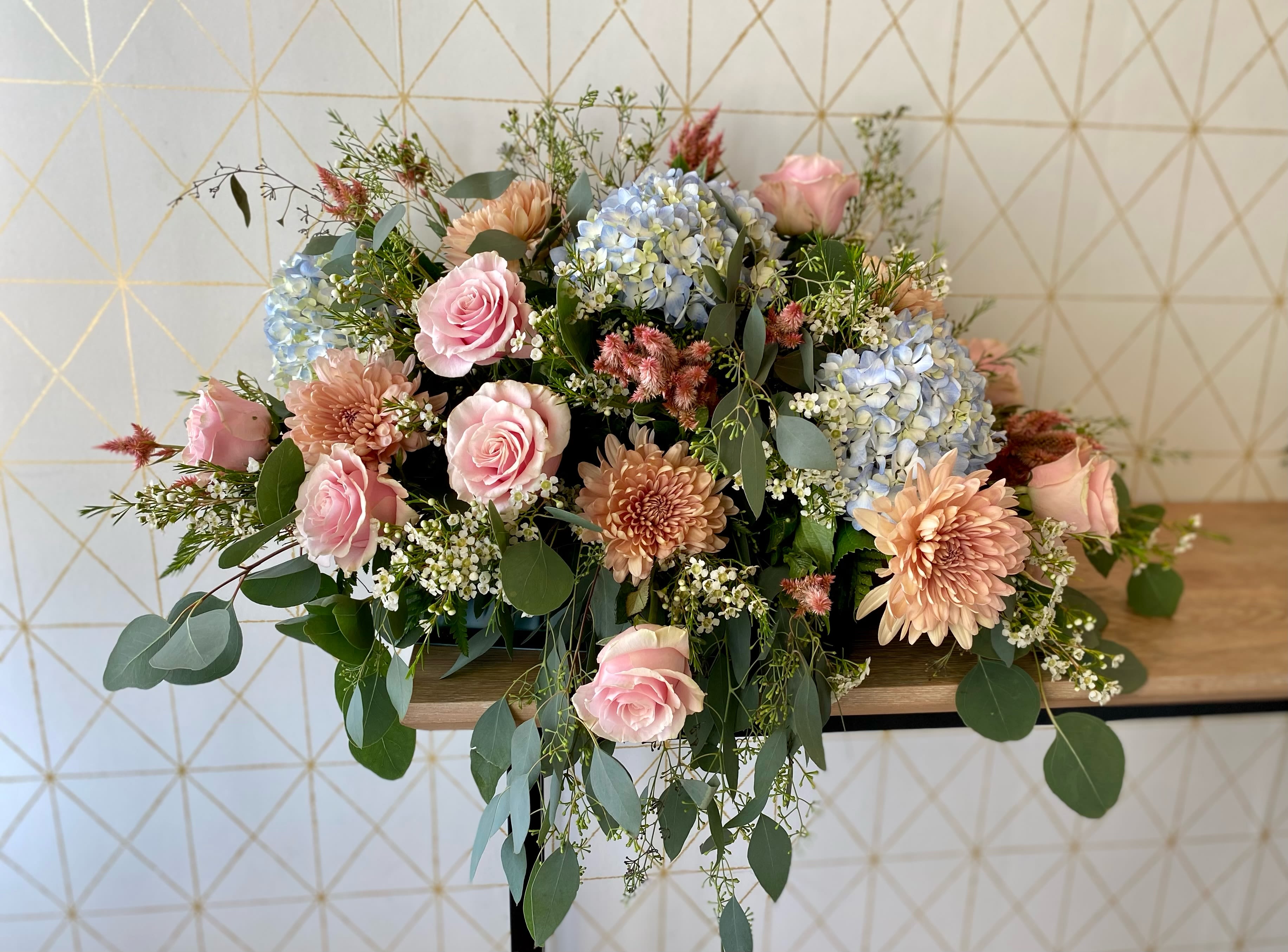 Call to order - Casket Spray - Honor your loved one with a beautiful, heartfelt tribute. Our custom casket sprays are thoughtfully designed with fresh seasonal blooms in the colors and flowers of your choice, creating a personal and meaningful arrangement. Whether you prefer something classic and elegant or vibrant and full of life, our designers will craft a spray that reflects your loved one's spirit and brings comfort to family and friends.   Available in a variety of sizes and styles. Please call us to discuss customization.