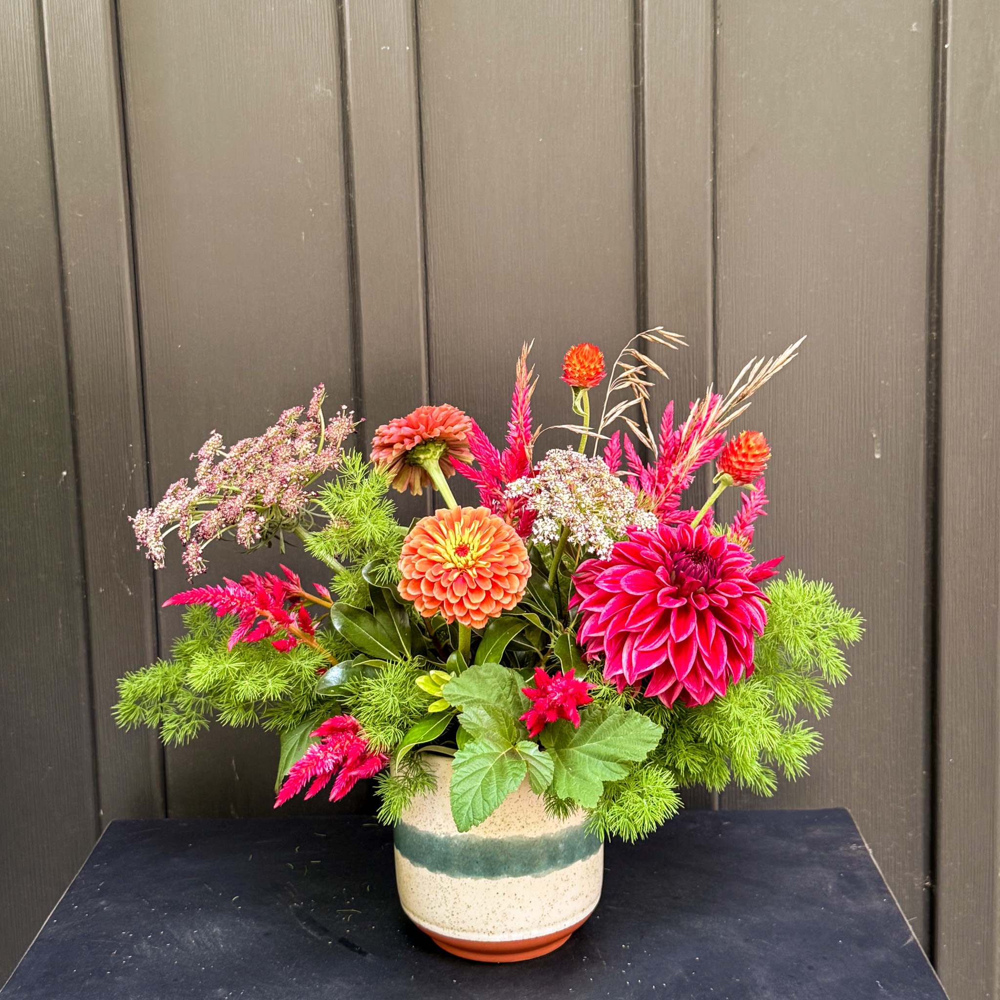 Bright mixed flower arrangement in a ceramic pot