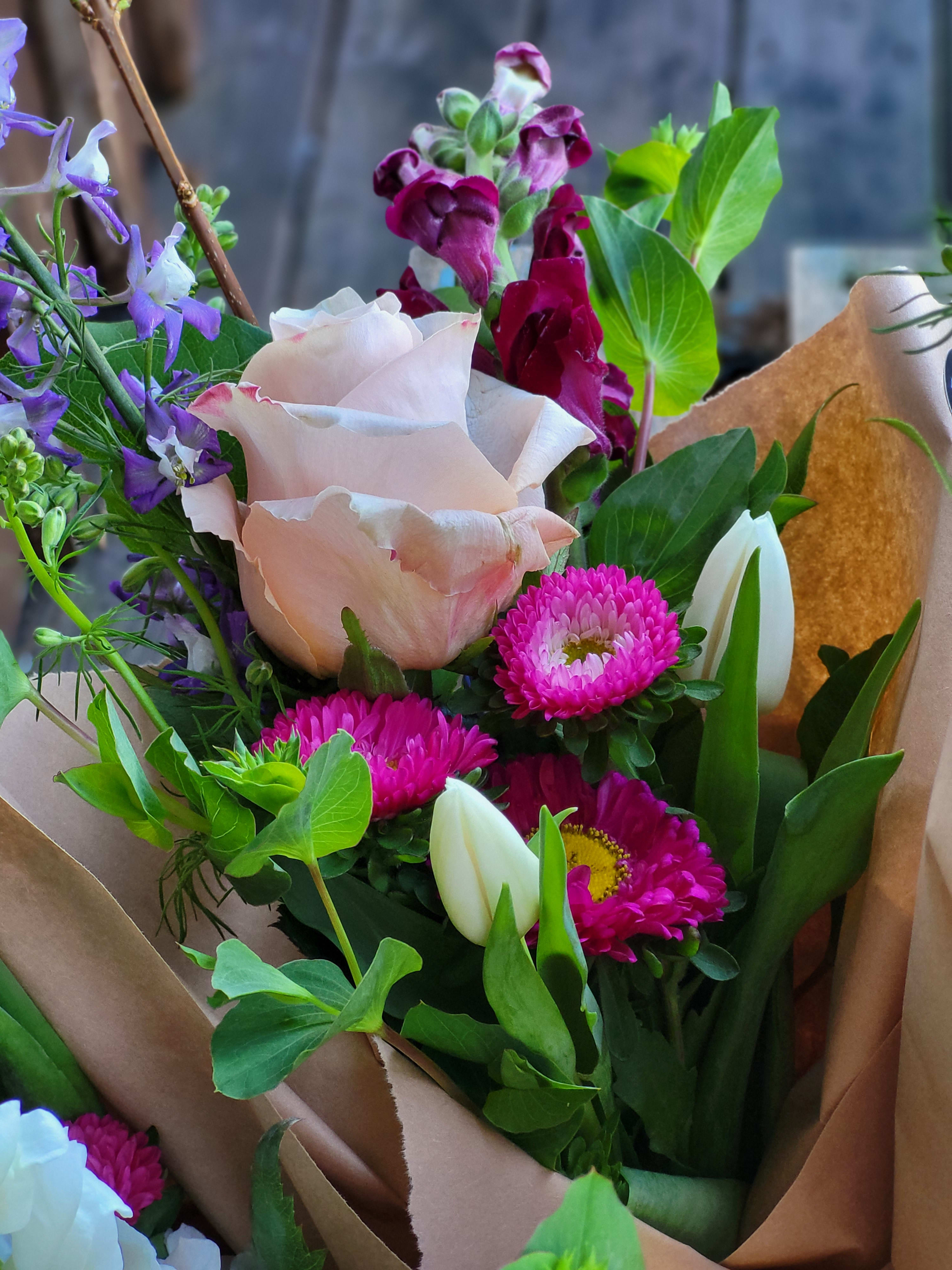 Bouquet of pink roses, magenta daisies, and purple snapdragons