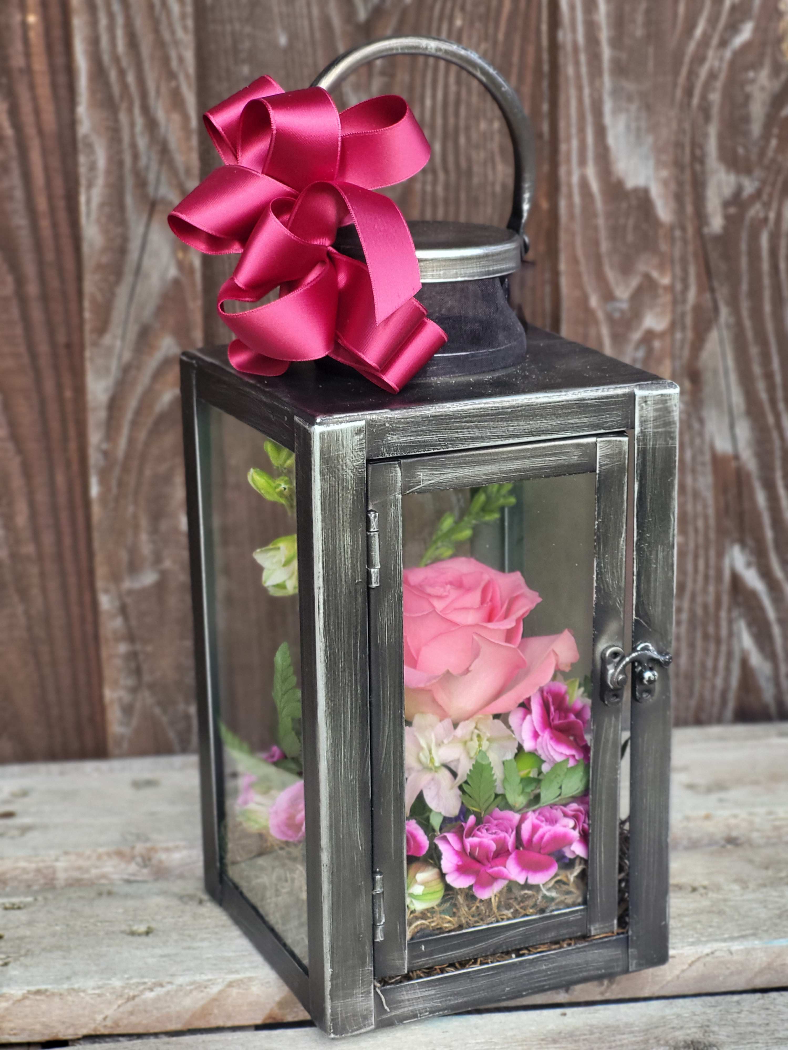 Black lantern with pink flowers and a magenta ribbon bow