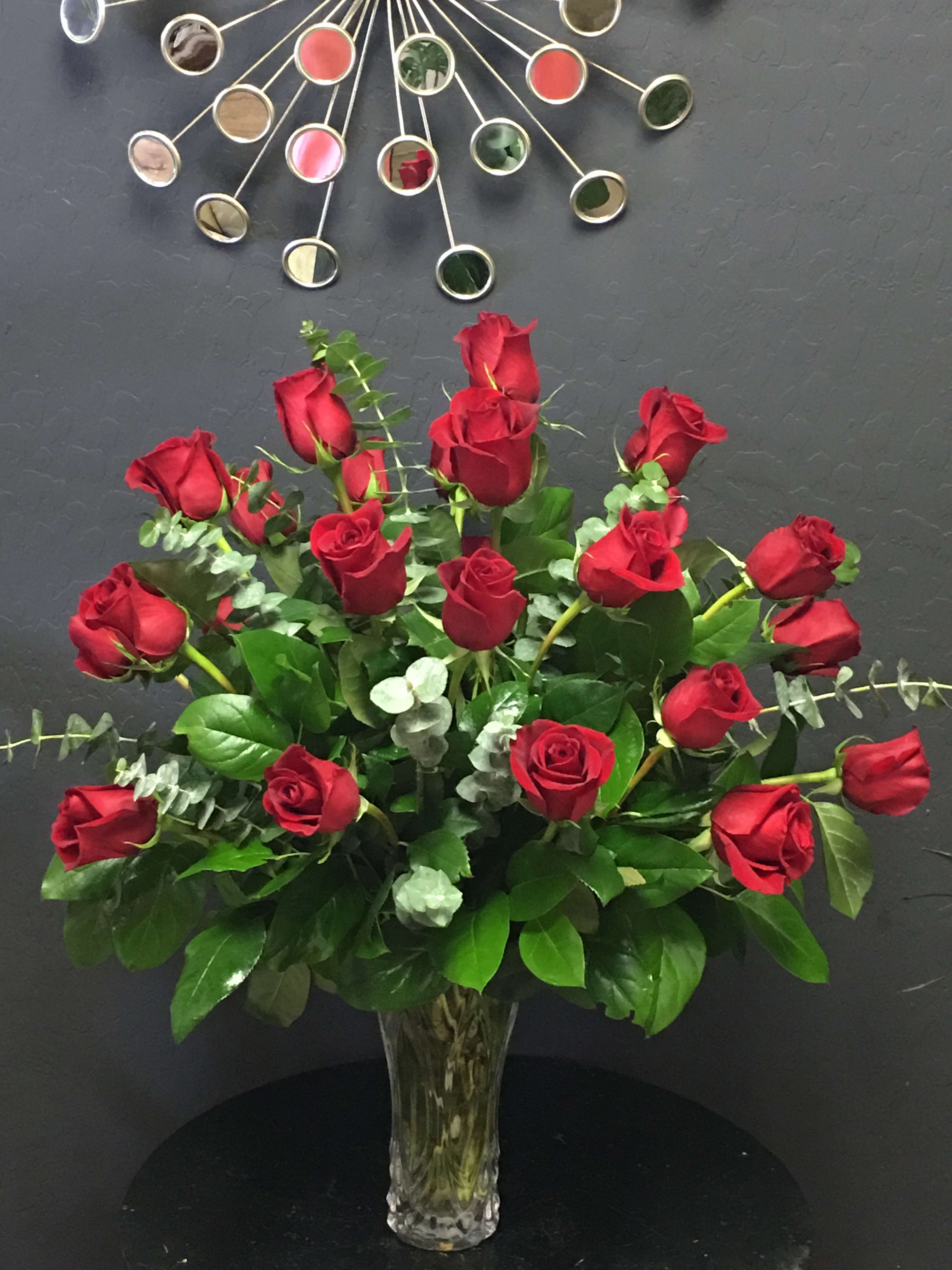 Red roses arranged in a clear glass vase