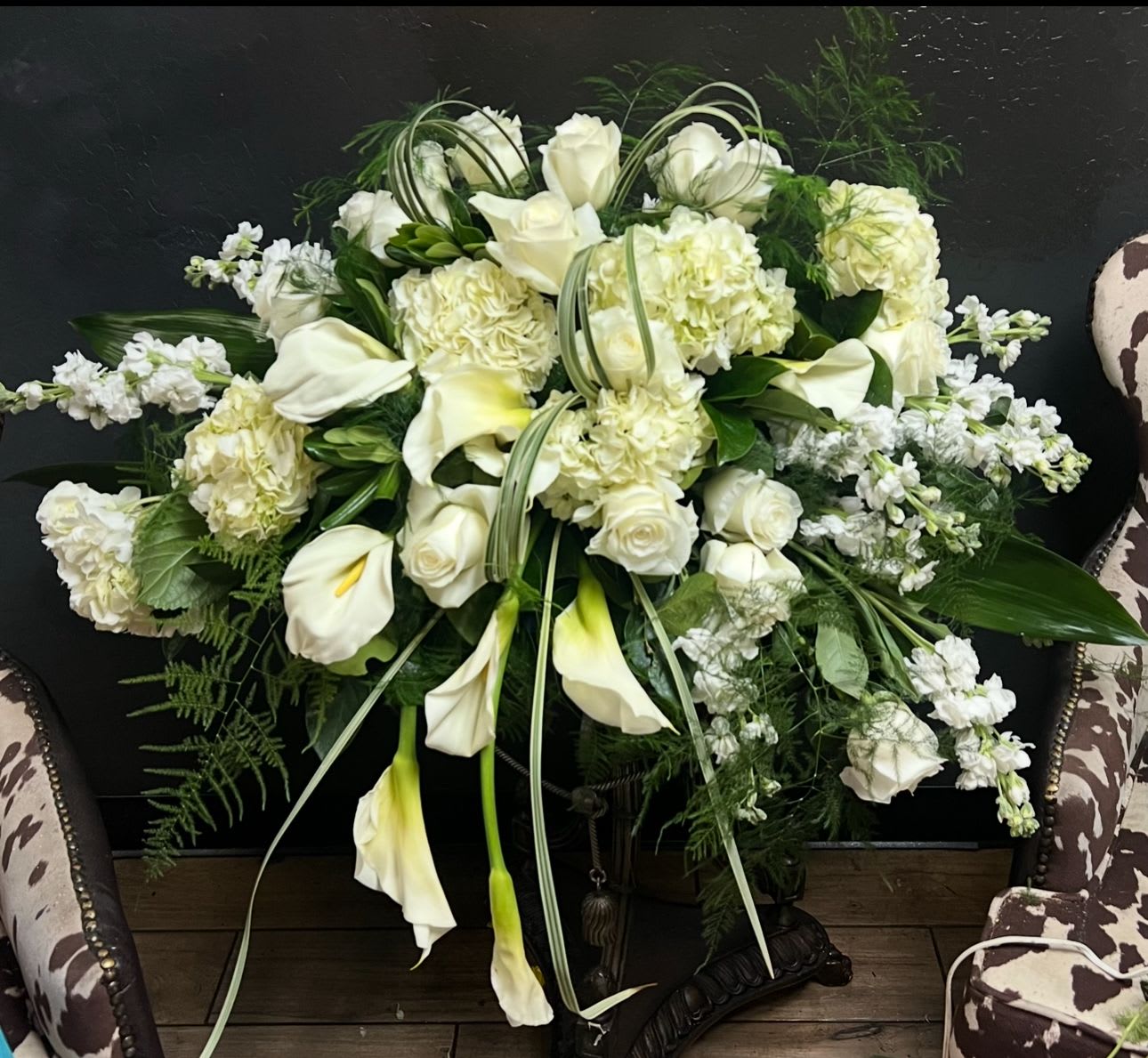 White floral arrangement with calla lilies, roses, and hydrangeas