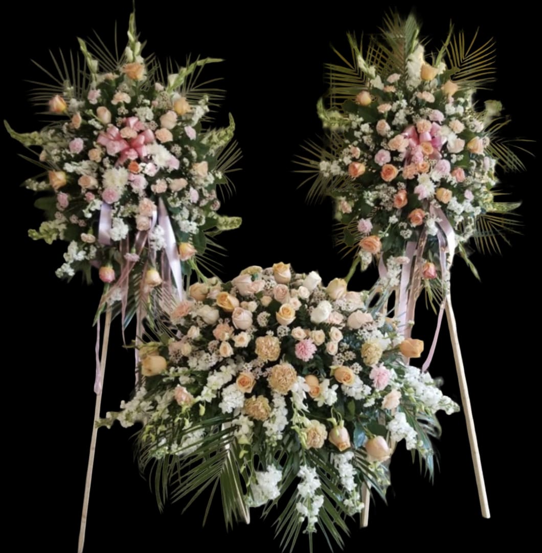 Three large floral standing sprays with pink and peach roses on easels