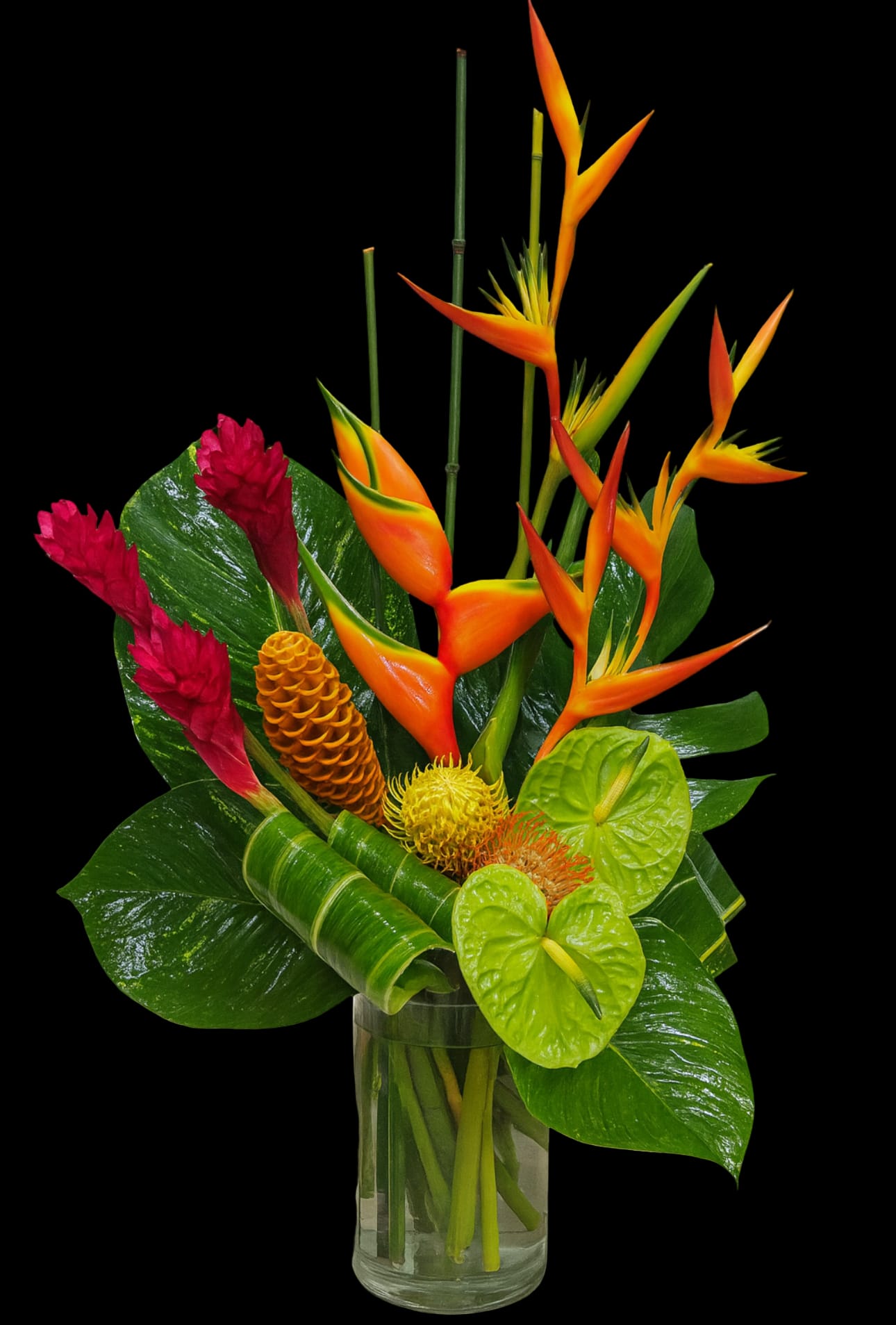 Tropical bouquet with orange bird-of-paradise and red ginger in a glass vase
