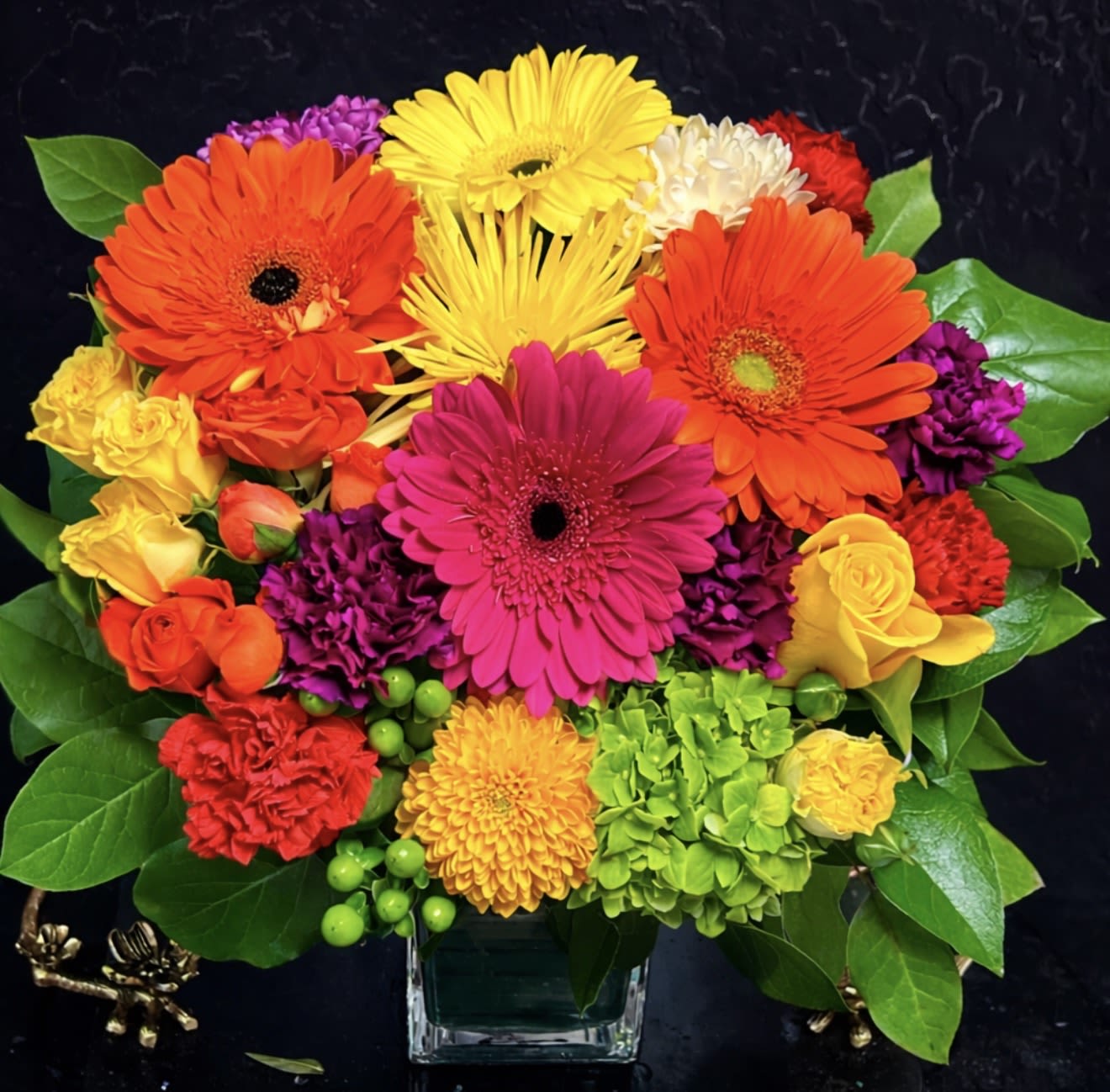 Colorful mixed bouquet in a clear square vase