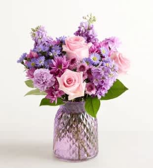 Pink and purple mixed bouquet in a textured glass vase
