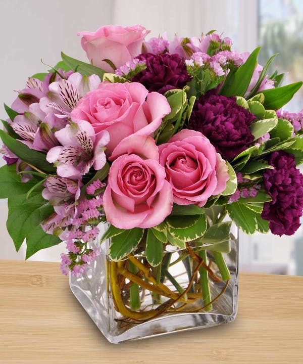 Pink and purple flower bouquet in a clear glass vase