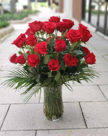 Red roses arranged in a clear glass vase