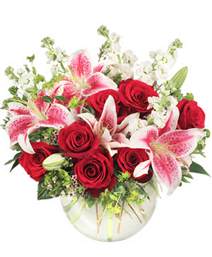 Bouquet of red roses and pink lilies in a clear glass vase