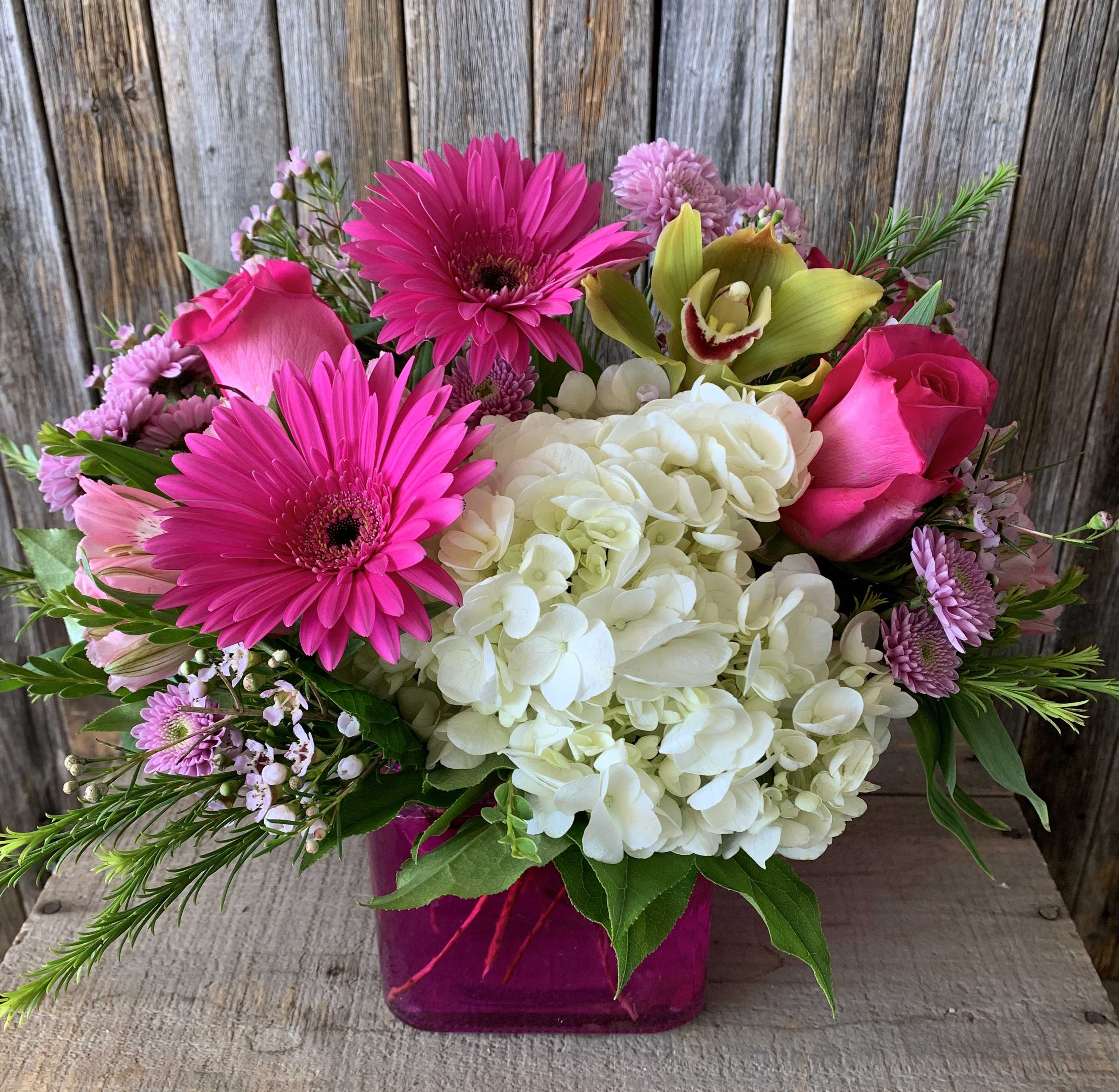 Pink and white mixed bouquet in a magenta vase