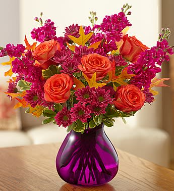 Plum Crazy for Fall - Product ID: 99165   EXCLUSIVE We admit it, we're crazy about this colorful bouquetâ¦and we bet theyâll be, too! A colorful mix of orange roses, lavender daisy poms and more is accented with unique dried oak leaves for some added Autumn charm. Hand-crafted in a striking purple glass vase by our expert florists, itâs a gift that'll leave them "ooh-ing" and "aah-ing", whatever the occasion. Arrangement of orange roses, fuchsia stock and purple daisy poms hand-gathered with variegated pittosporum and dried oak leaves Artistically designed by our select florists in a purple glass vase; measures 7"H Large arrangement measures approximately 14"H x 12"L Medium arrangement measures approximately 13"H x 11"L Small arrangement does not include hypericum and measures approximately 12"H x 10"L Our florists select the freshest flowers available, so colors, varieties and container may vary due to local availability