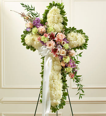 Peace and Prayers Standing Cross - Pastel - Product ID: 91394   This beautiful floral tribute shows your compassion, faith and love during this difficult time. This standing spray arrangement â in the shape of a cross â is created from fresh white mums and pastel-colored roses, lilies, stock, lisianthus, carnations and more Traditionally sent directly to the funeral home by family members or friends and displayed on a stand Our florists use only the freshest flowers available so varieties and colors may vary Measures approximately 42"H x 28"L without easel