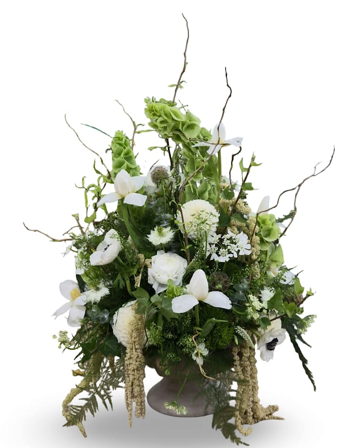 Tall white and green floral arrangement in a pedestal vase