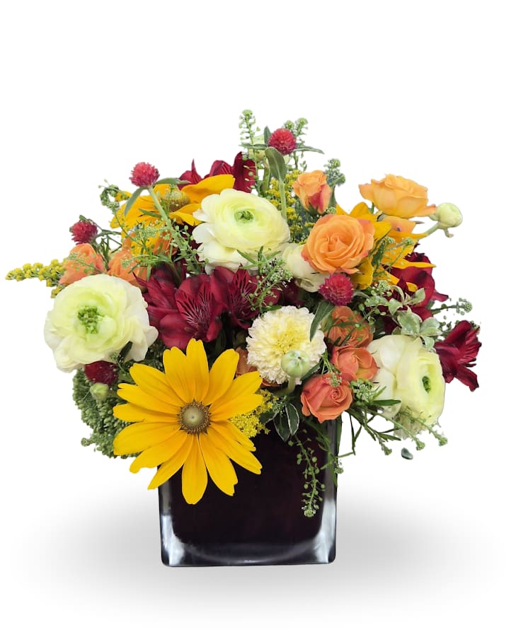 Mixed bouquet in a black square vase with yellow, orange, white, and burgundy flowers