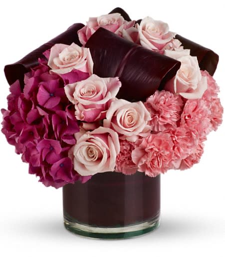 Pink roses and hydrangeas arranged in a dark glass vase