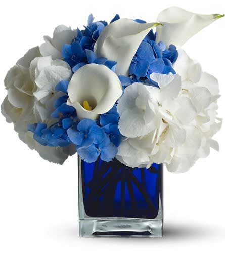 Blue and white floral arrangement in a square glass vase