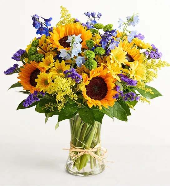 Fields of Europe Summer - Inspired by the colorful charm of the European countryside, our best-selling summer bouquet is gathered with fresh-picked blooms, revealing the rustic beauty of nature. Shades of golden yellow and rich blue pop against lush greenery, creating a timeless gift for someone special to enjoy.