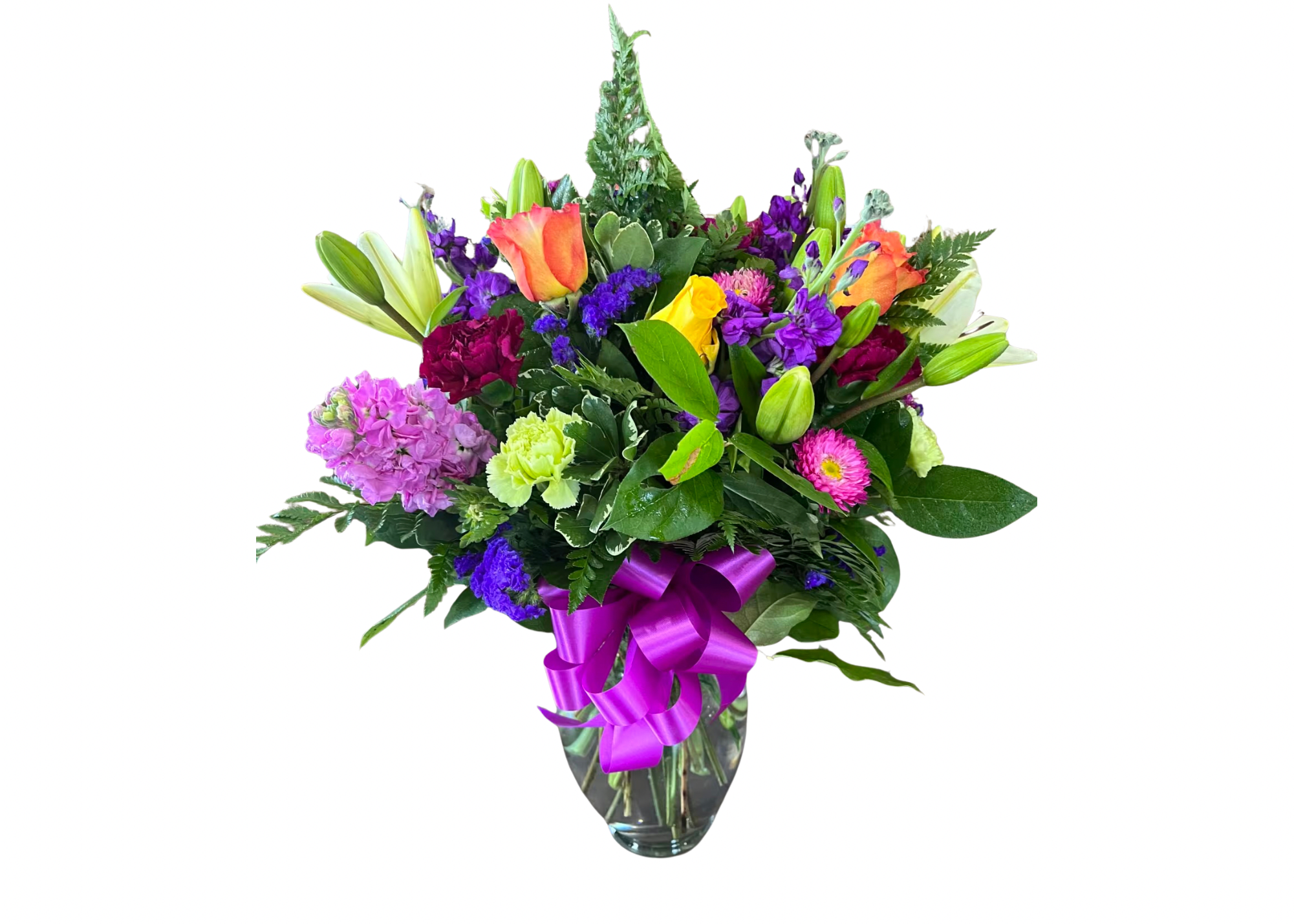 Mixed bouquet of colorful flowers in a glass vase with a purple ribbon