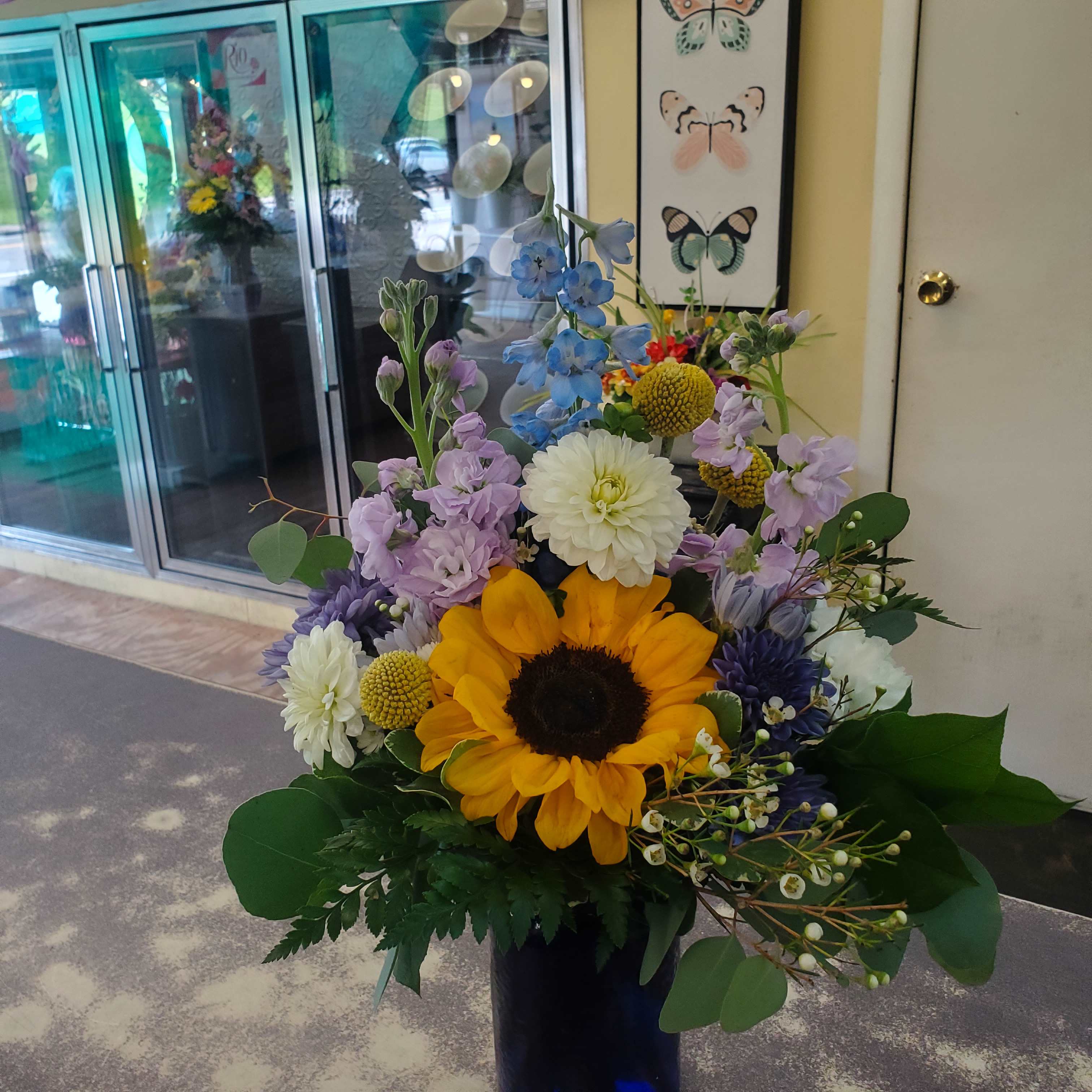 Mixed bouquet with a sunflower in a dark vase