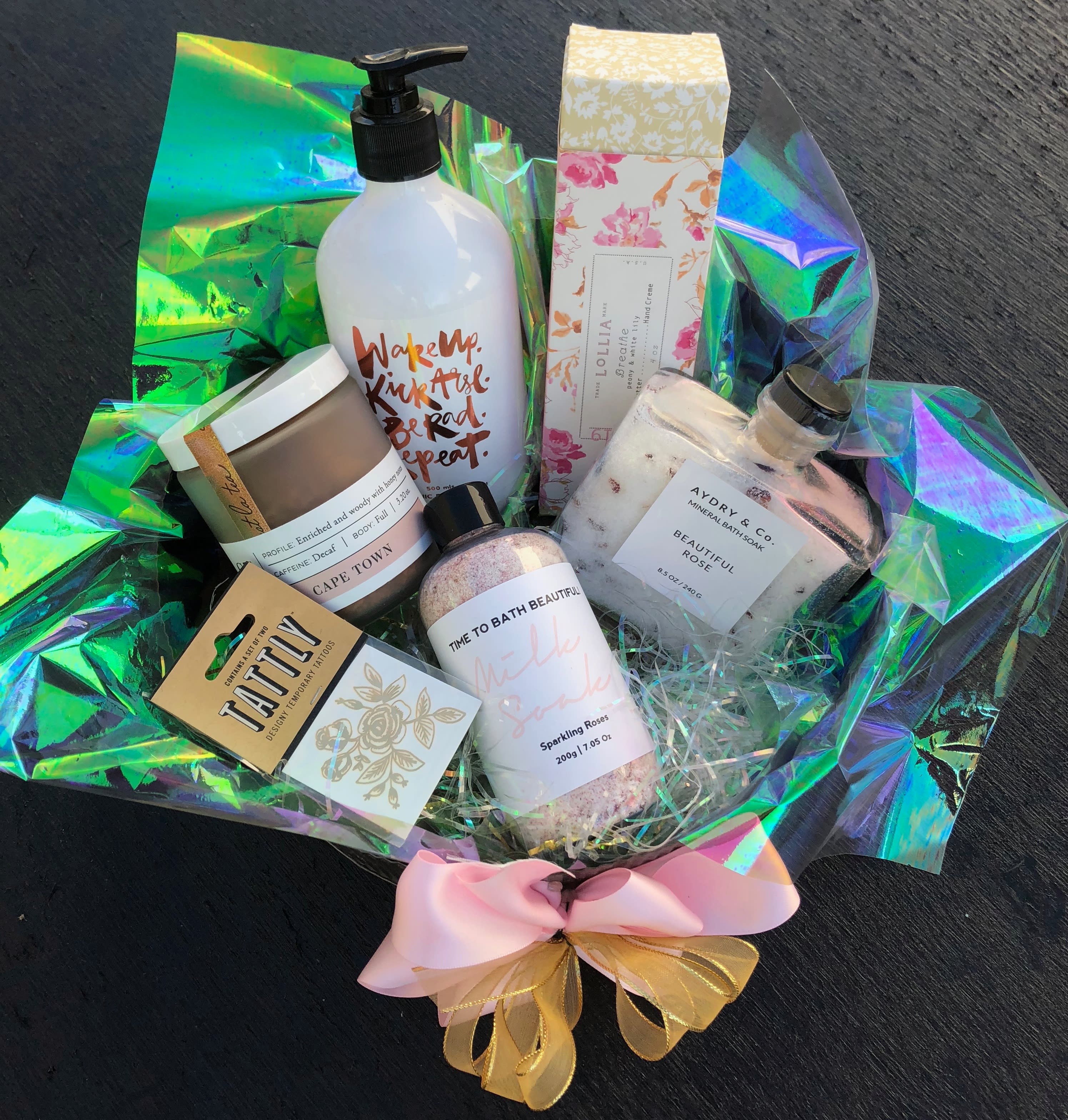 Bath and body gift basket with bottles, jars, and a pink bow