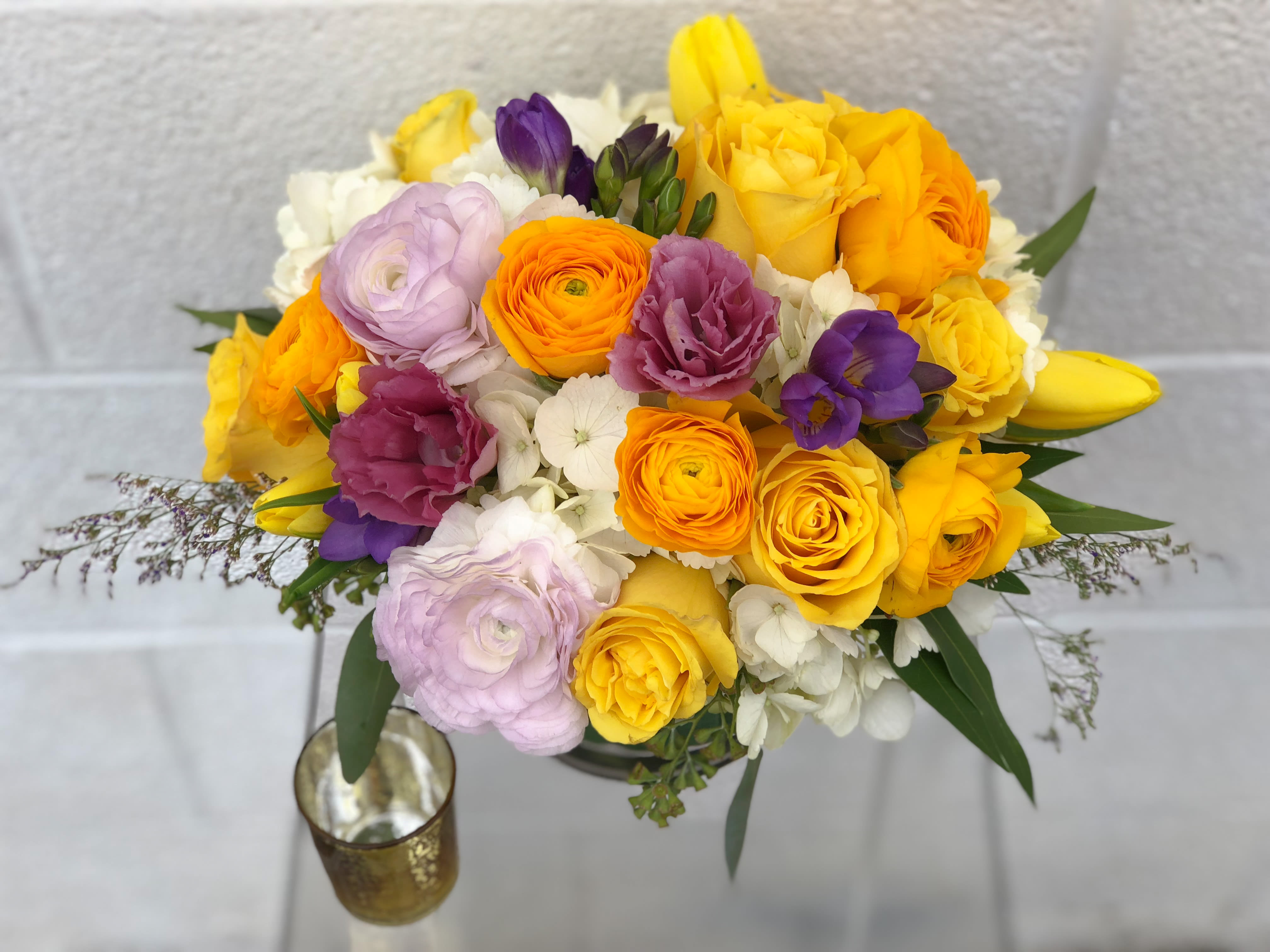 Bouquet of yellow, orange, purple, and white flowers in a vase