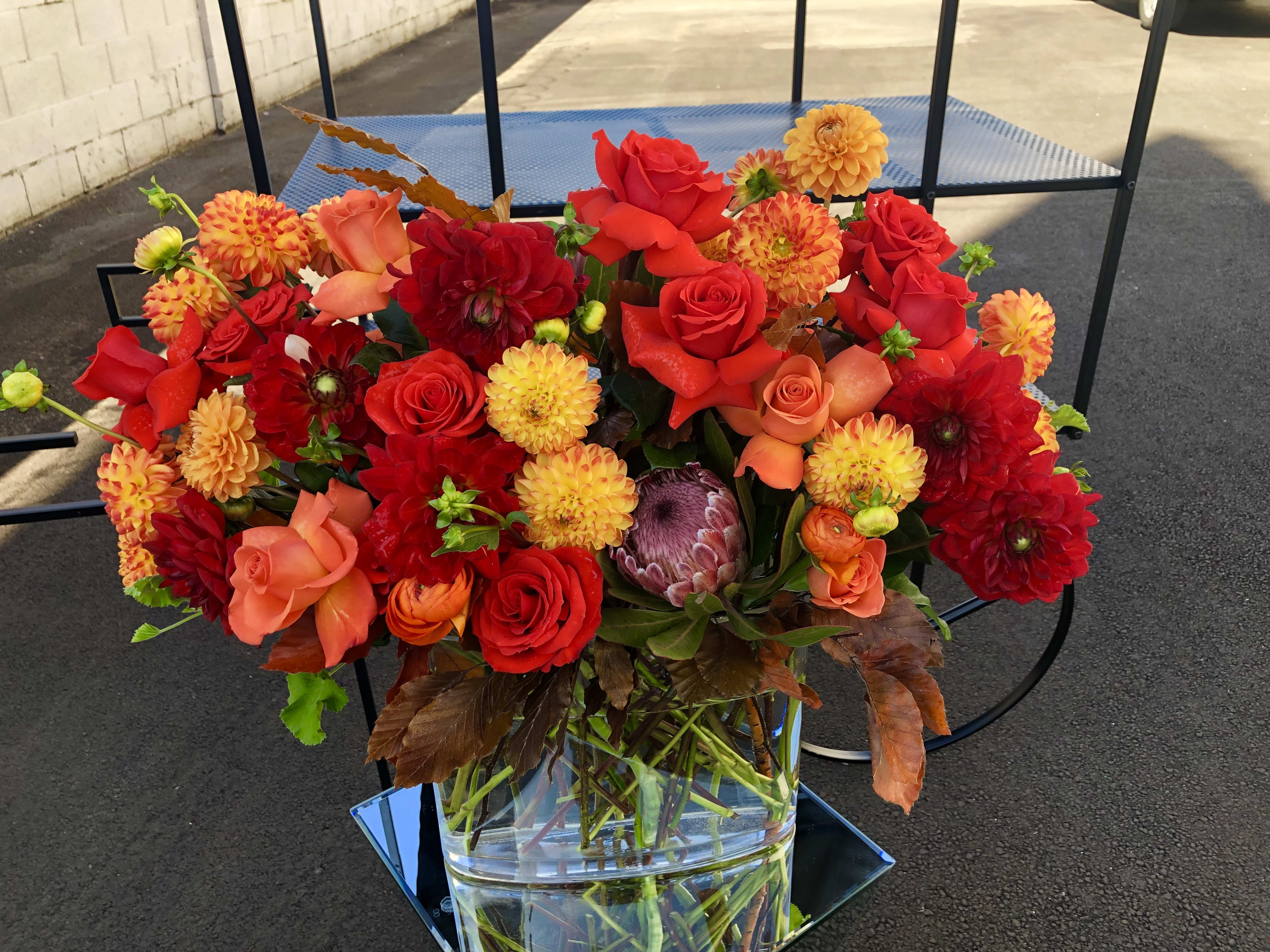 Bright red and orange mixed bouquet in a clear glass vase