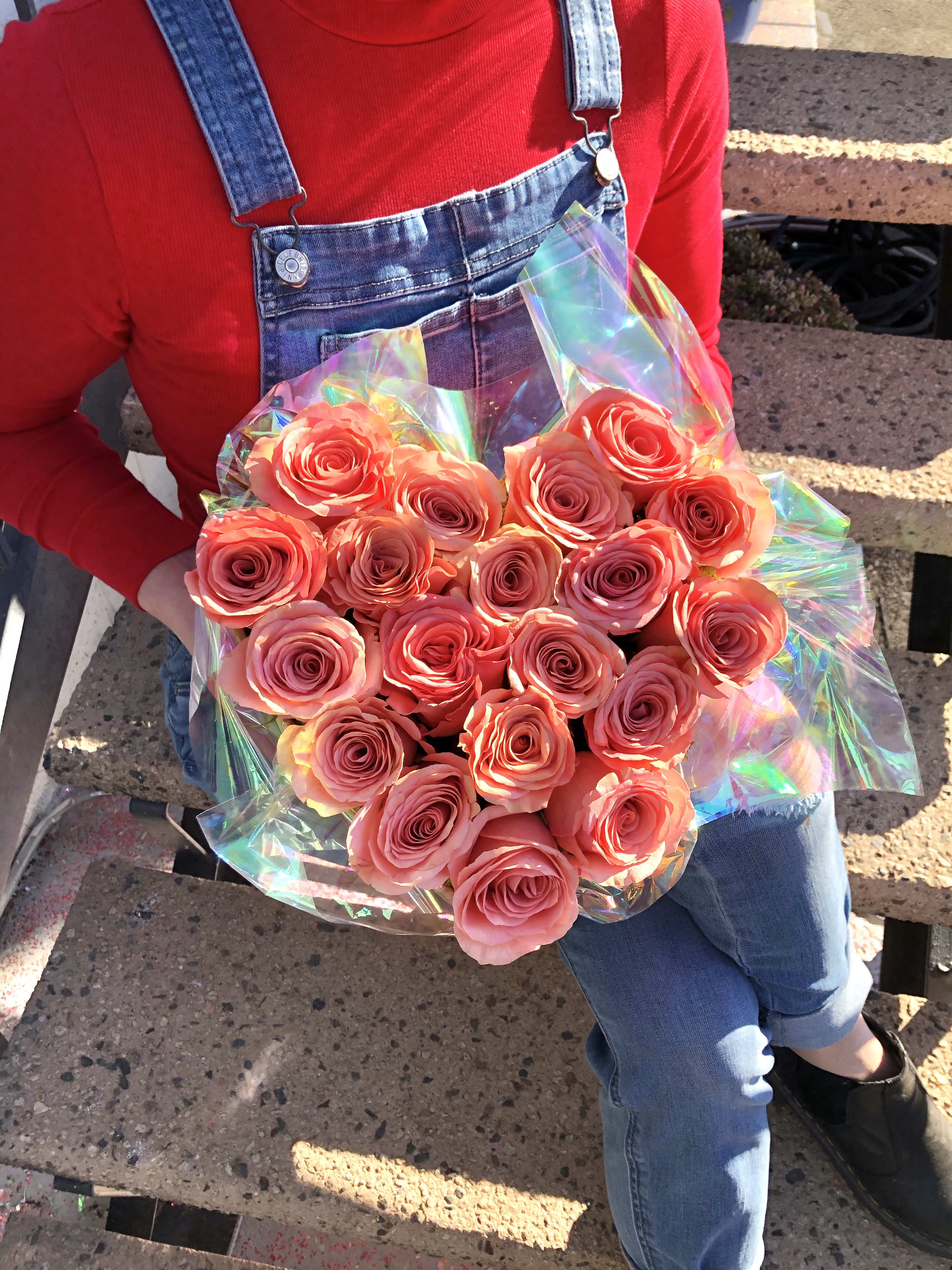 Bouquet of pink roses wrapped in iridescent plastic