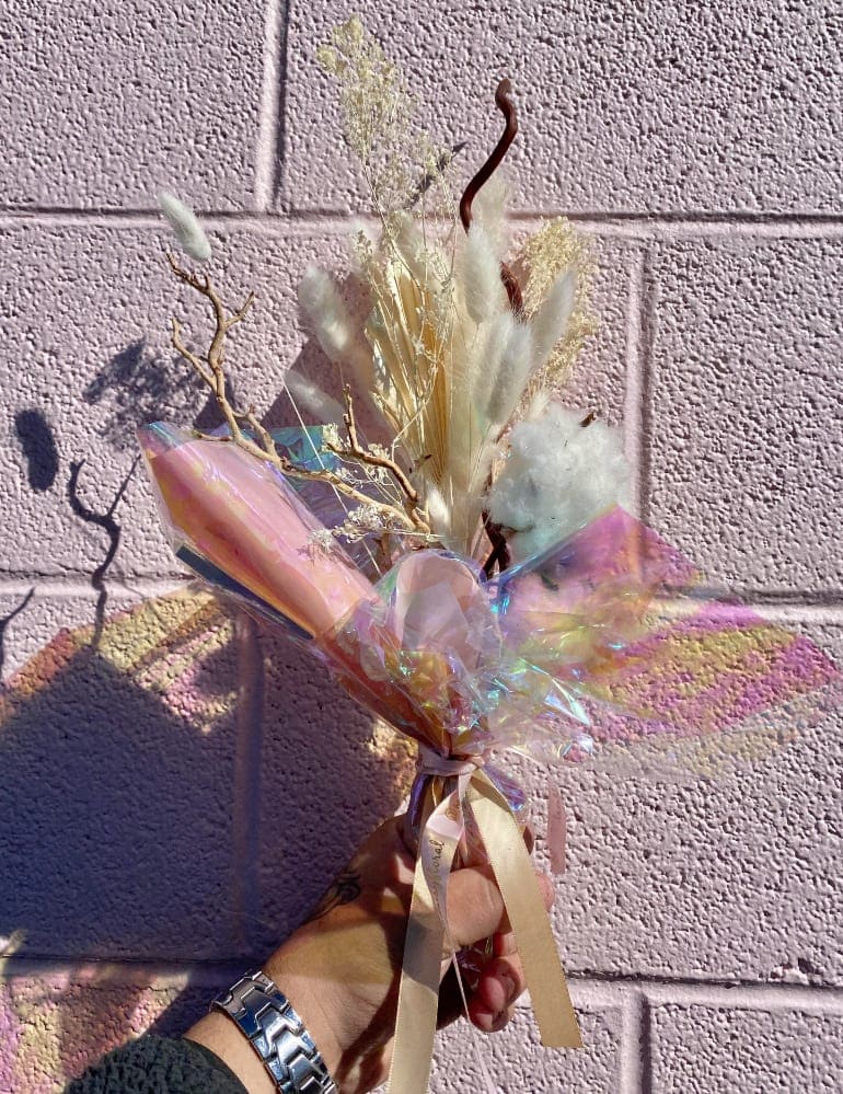 Dried bouquet with white fluffy grasses and iridescent wrap