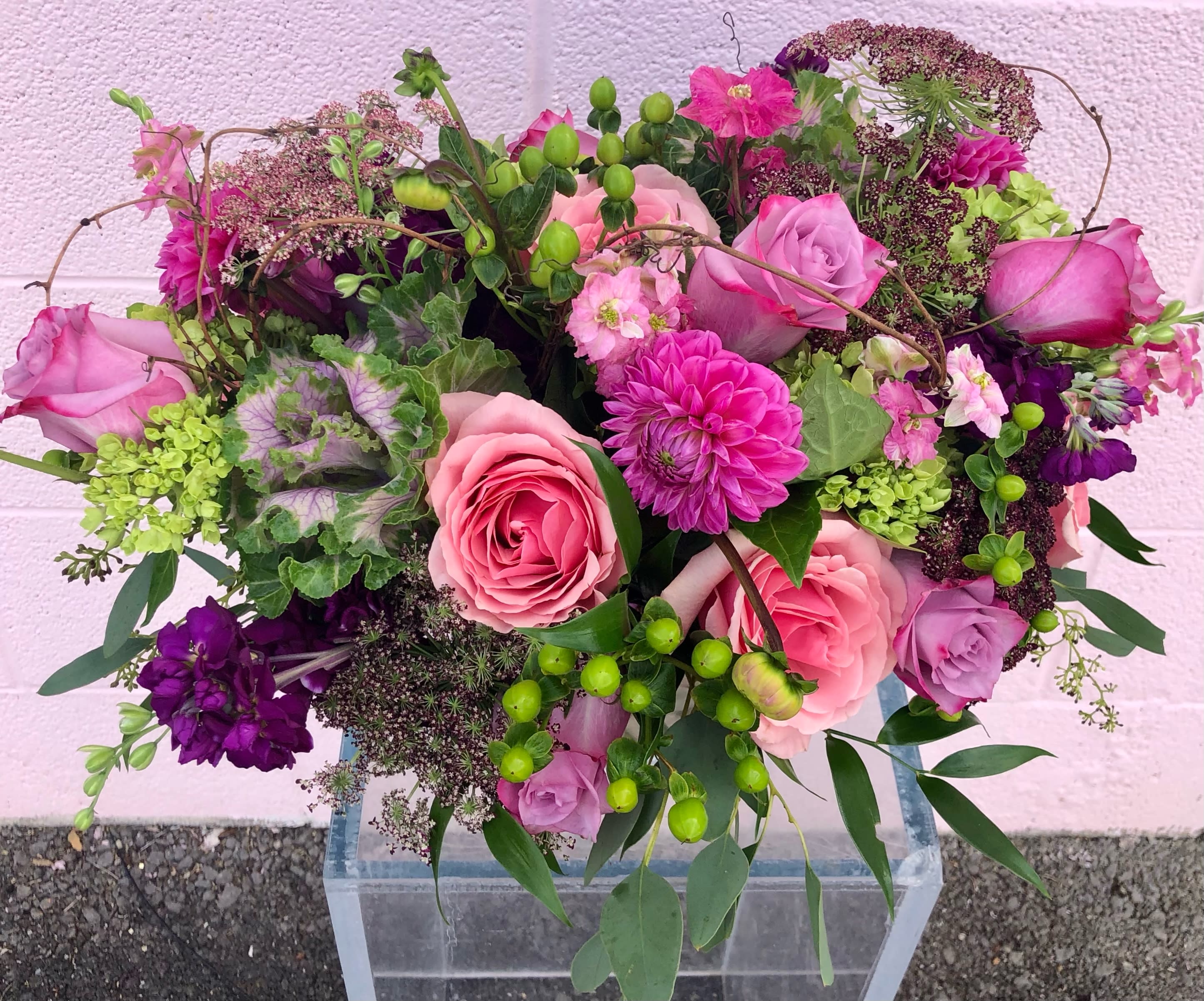 Pink and purple mixed bouquet with roses in a clear vase