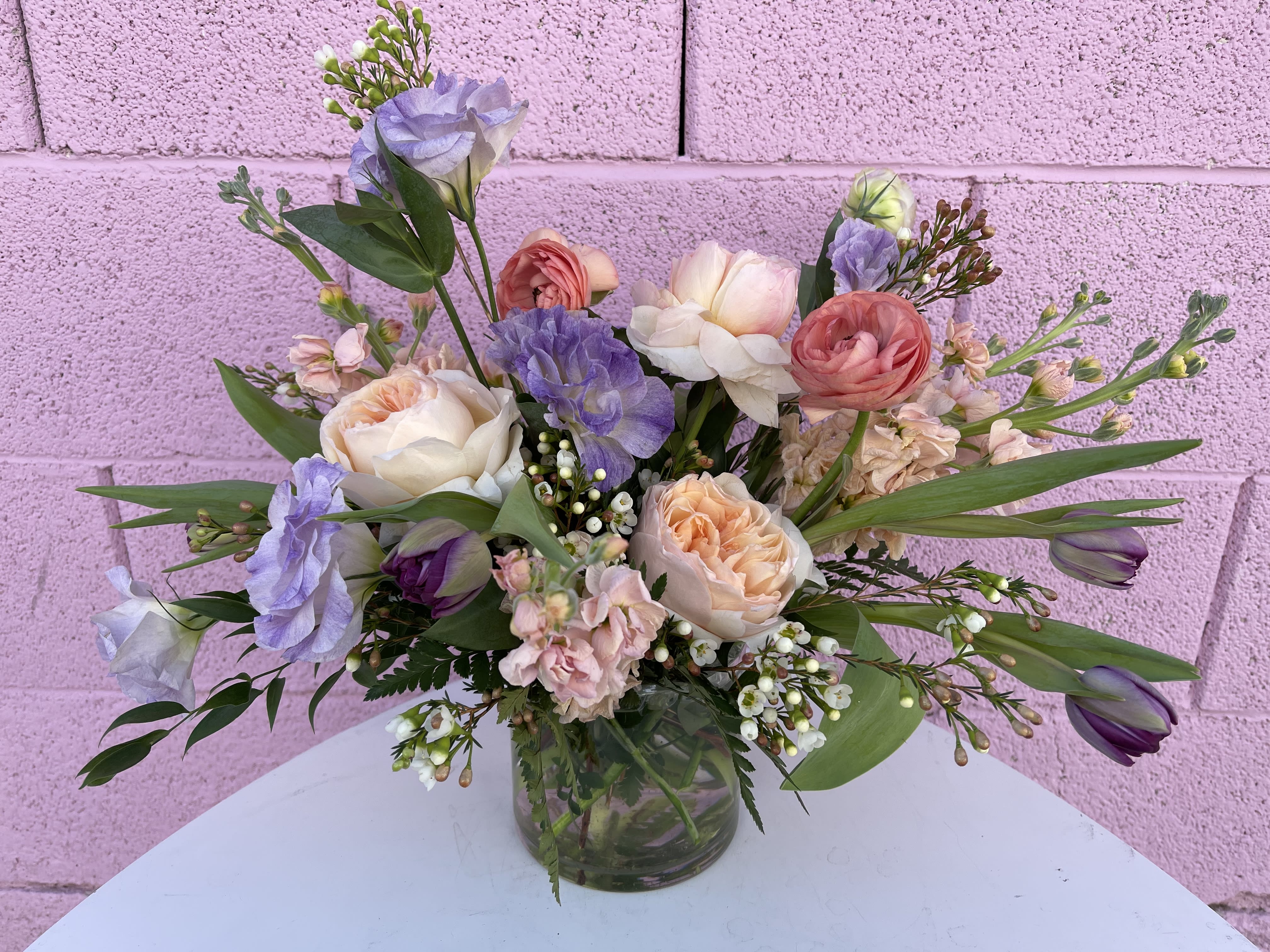 Pastel bouquet of roses, tulips, and lisianthus in a glass vase