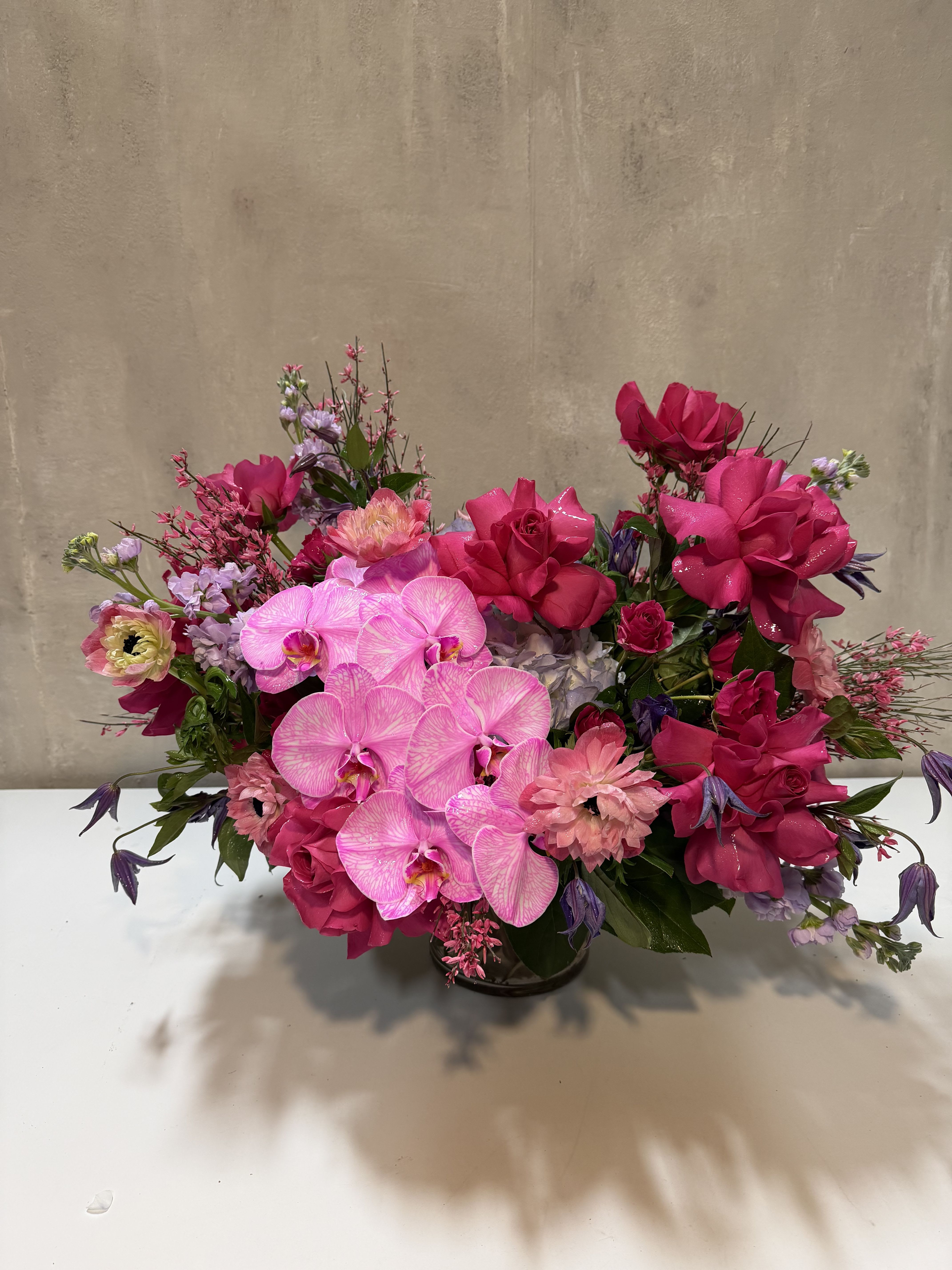 Pink and purple floral arrangement in a low vase
