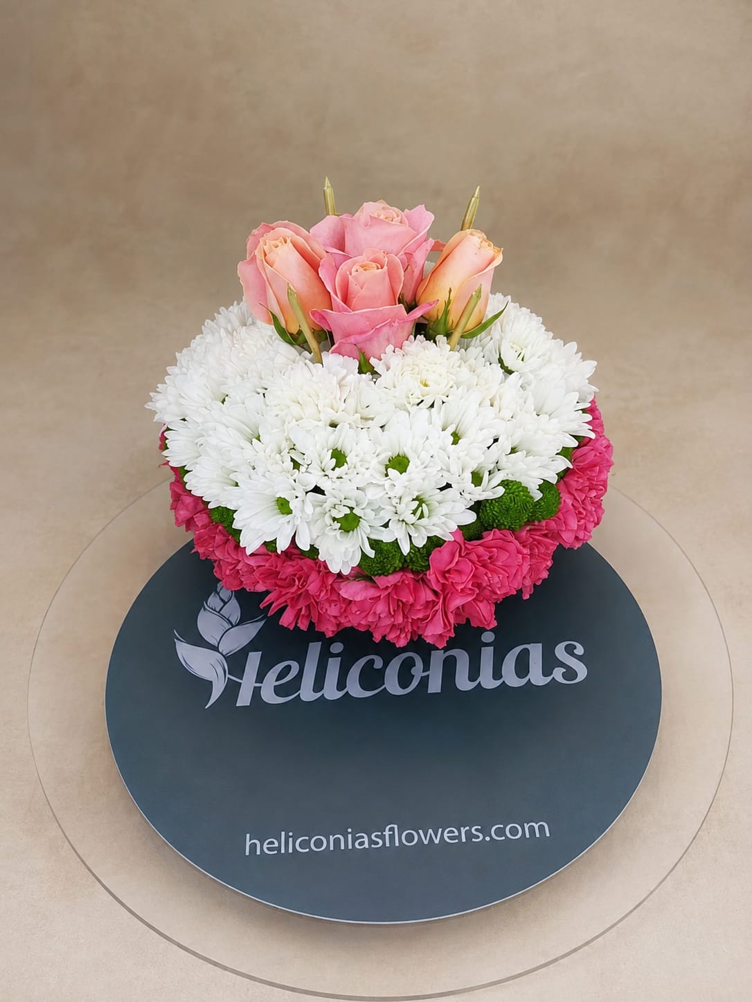 Pink roses and white daisies in a round floral arrangement