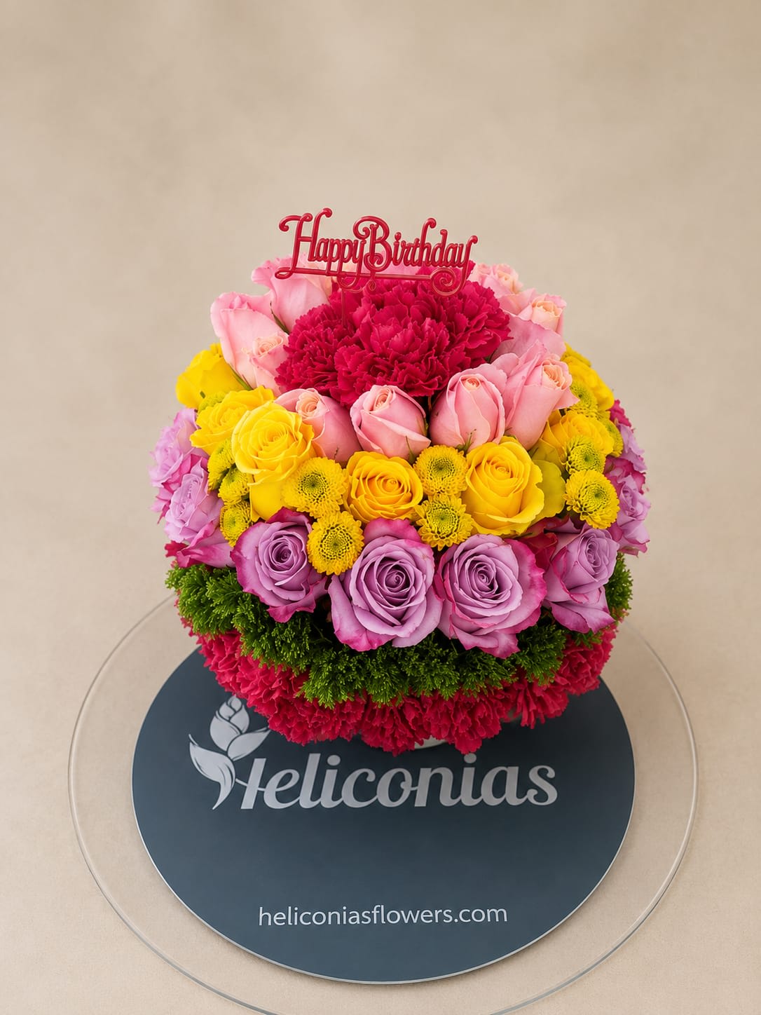 Round bouquet of pink, yellow, and lavender flowers with a Happy Birthday topper