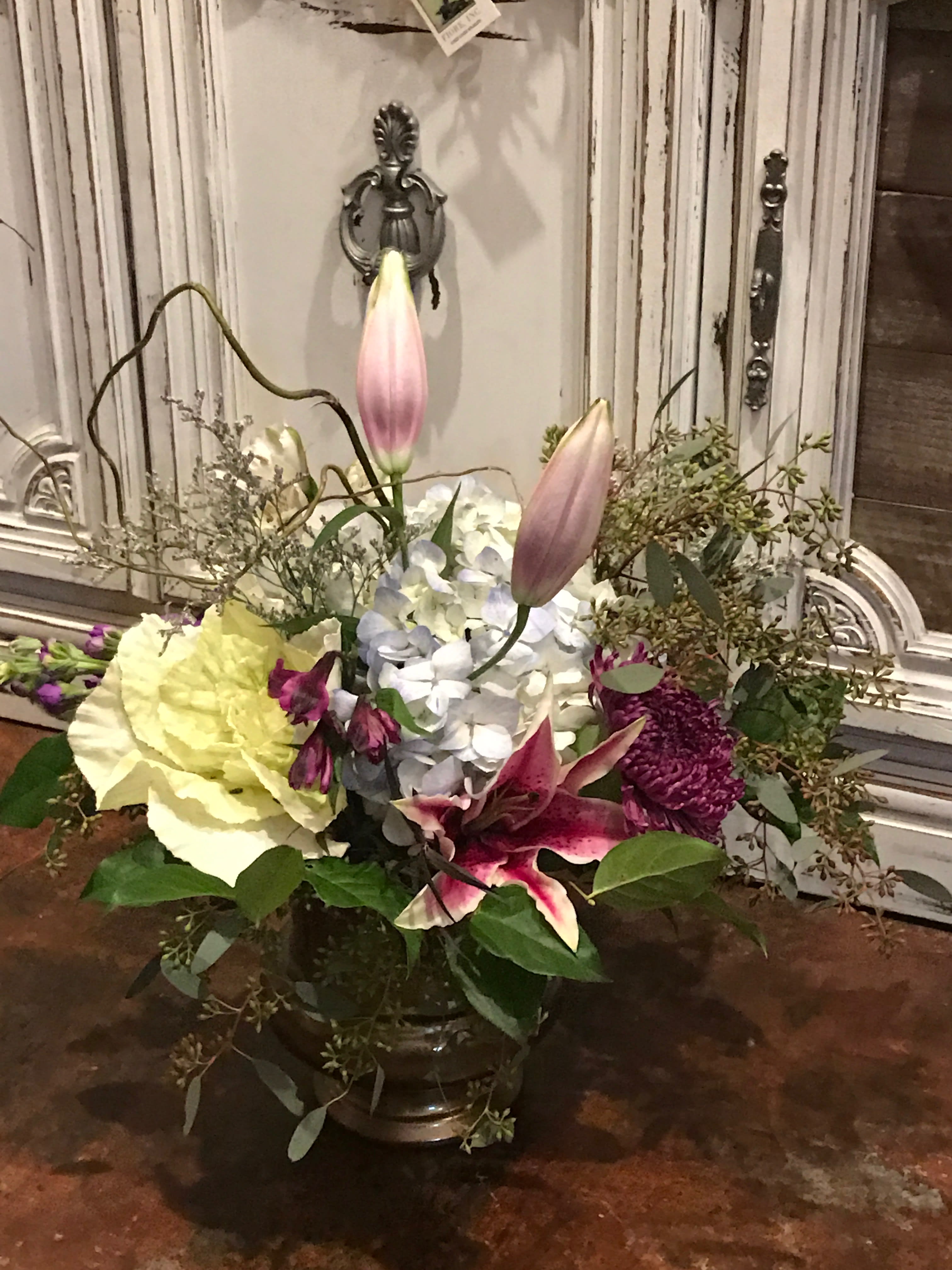 Mixed floral arrangement with lilies, hydrangea, and chrysanthemums in a vase