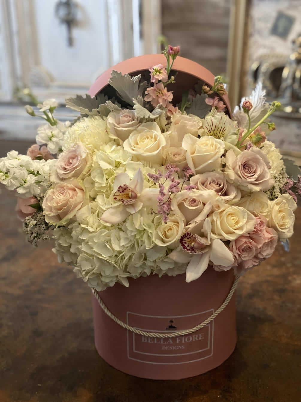 Sweet Blooms - An elegant flower arrangement designed with white and pastel pink colors for softer tones. A perfect flower arrangement for a special events. This arrangement consists of roses, spray roses, orchids,stock and dusty miller. 