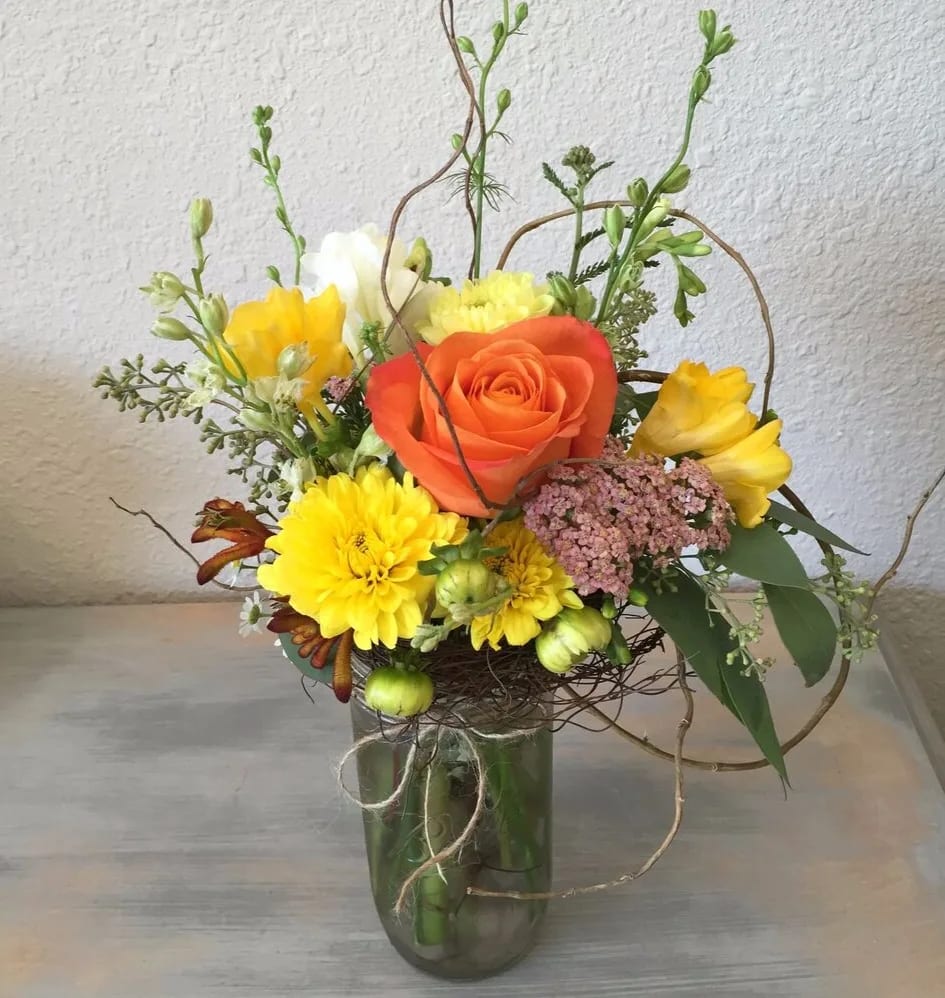 Spring Bouquet - Bouquet with yellow mums and orange roses in a glass vase. Deliver the colors of spring to any loved one or friend with this vibrant, cheery design.